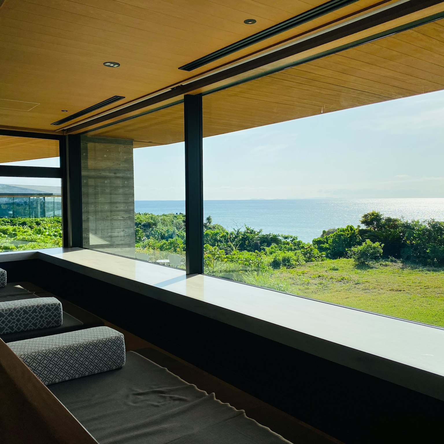 Espacio interior moderno con ventana que da al océano
