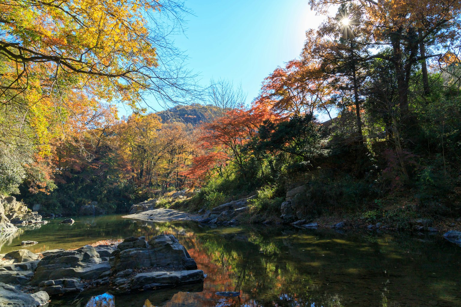 Ruhige Flusslandschaft mit bunten Herbstblättern im Spiegel