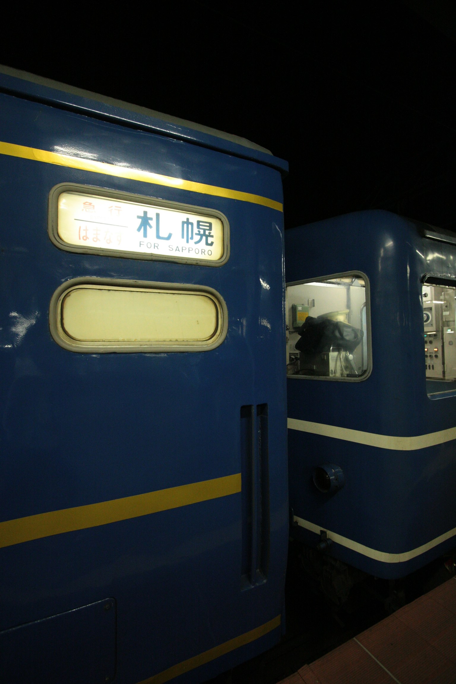 夜间窗户上有札幌标志的蓝色火车
