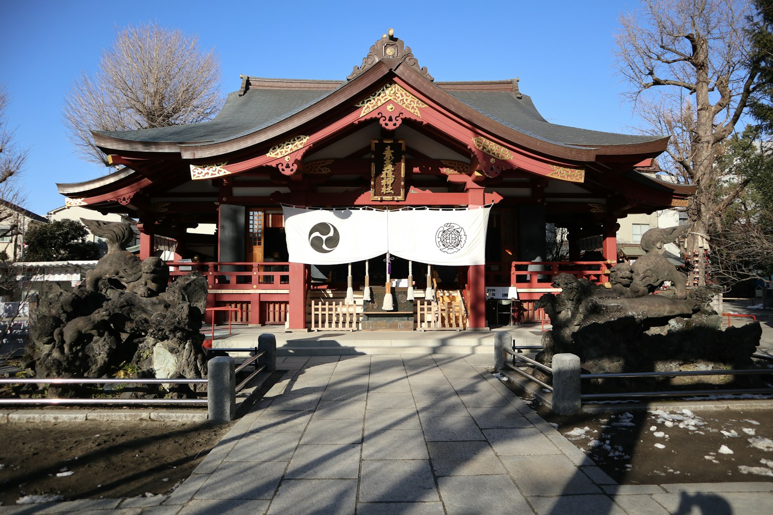 在晴朗藍天下的紅色屋頂和白色幕布的神社