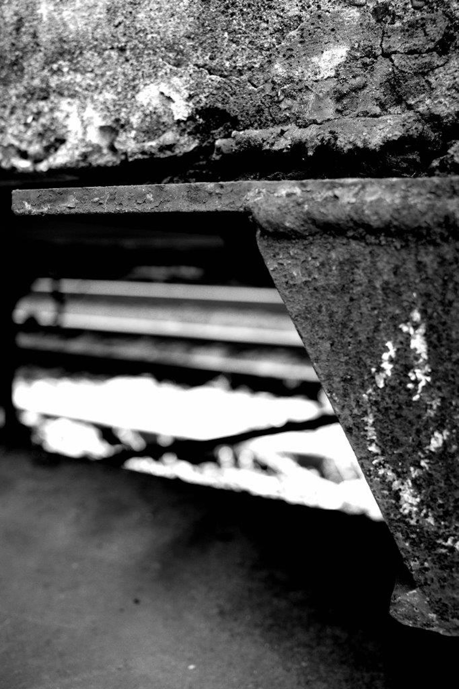 Close-up of a metallic structure with a textured surface and blurred background lines in black and white