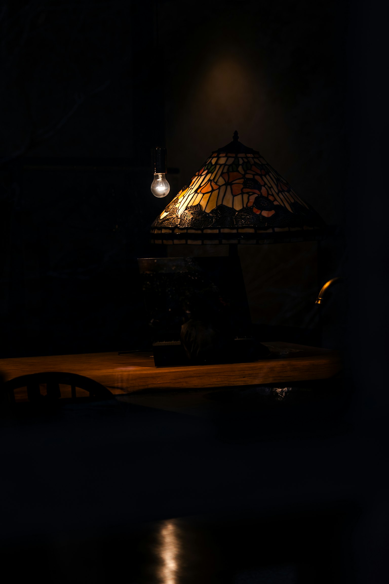 Une belle lampe éclairée sur un fond sombre avec une partie d'une table visible