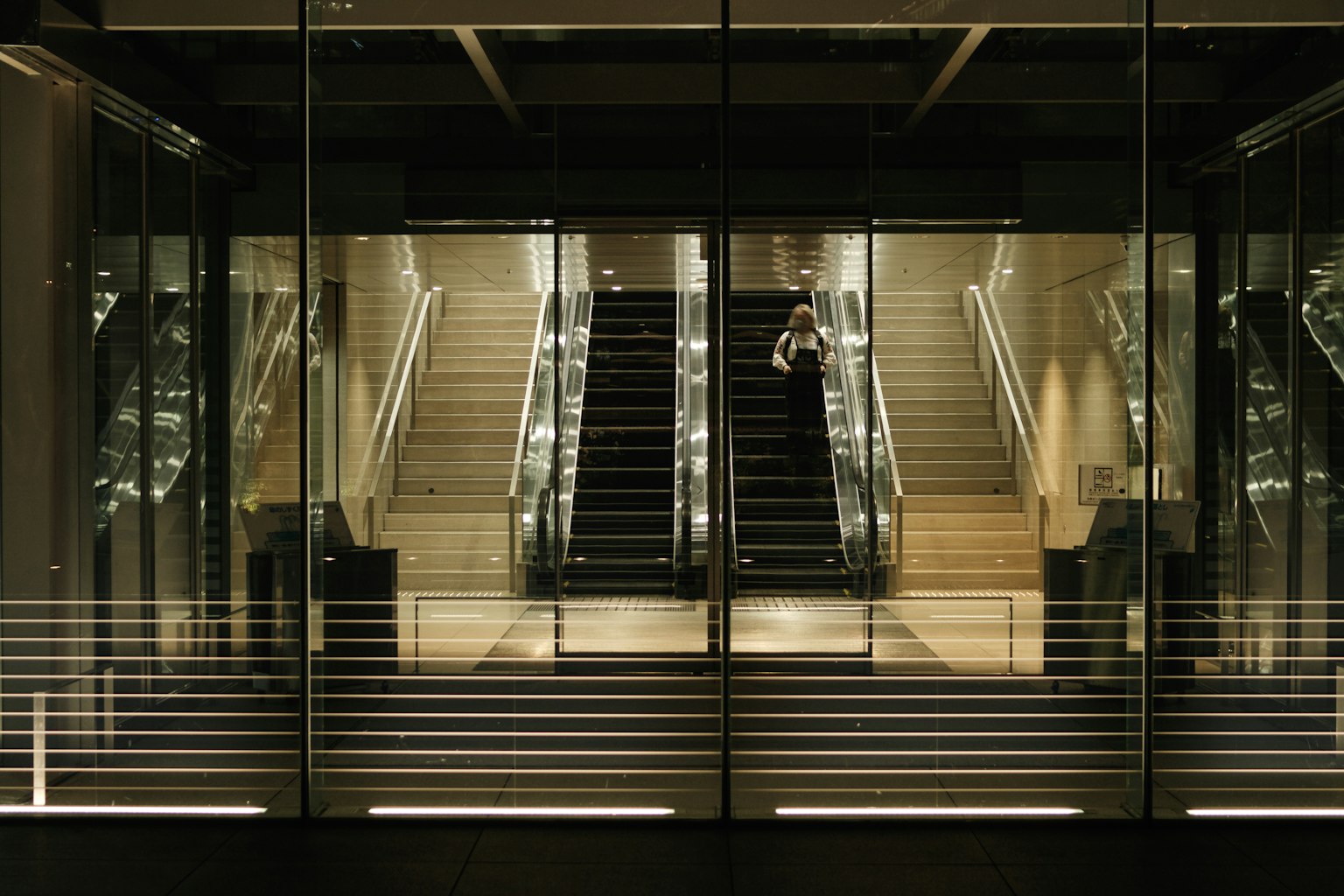 Interior view of escalators and stairs surrounded by glass