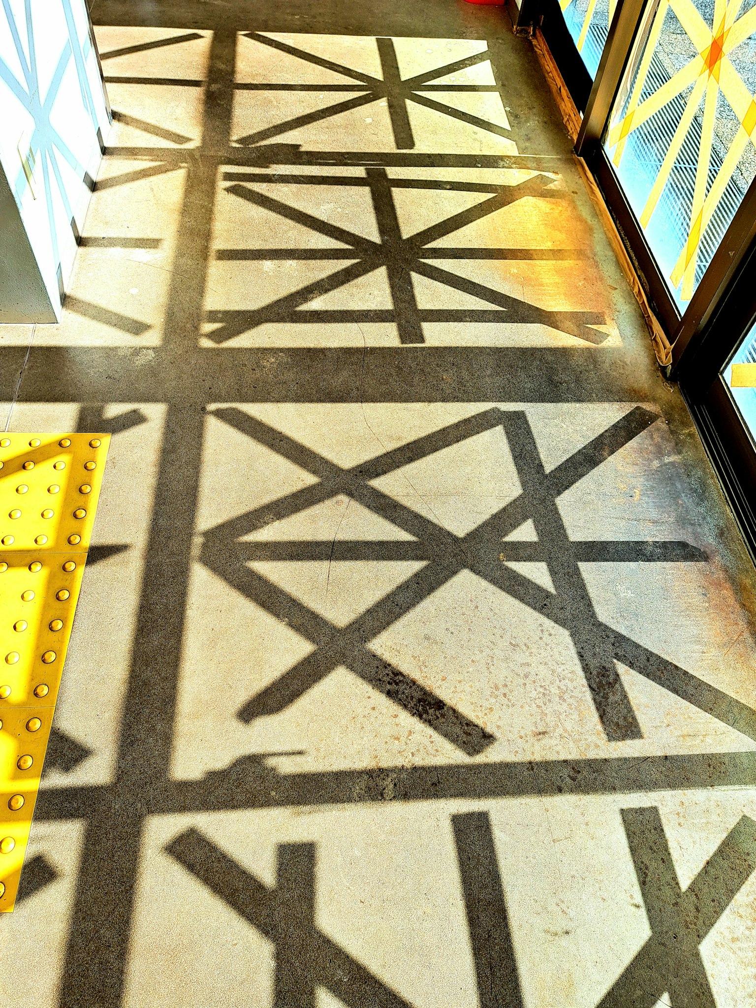 Motif de sol avec des lignes noires entrecroisées et accents jaunes