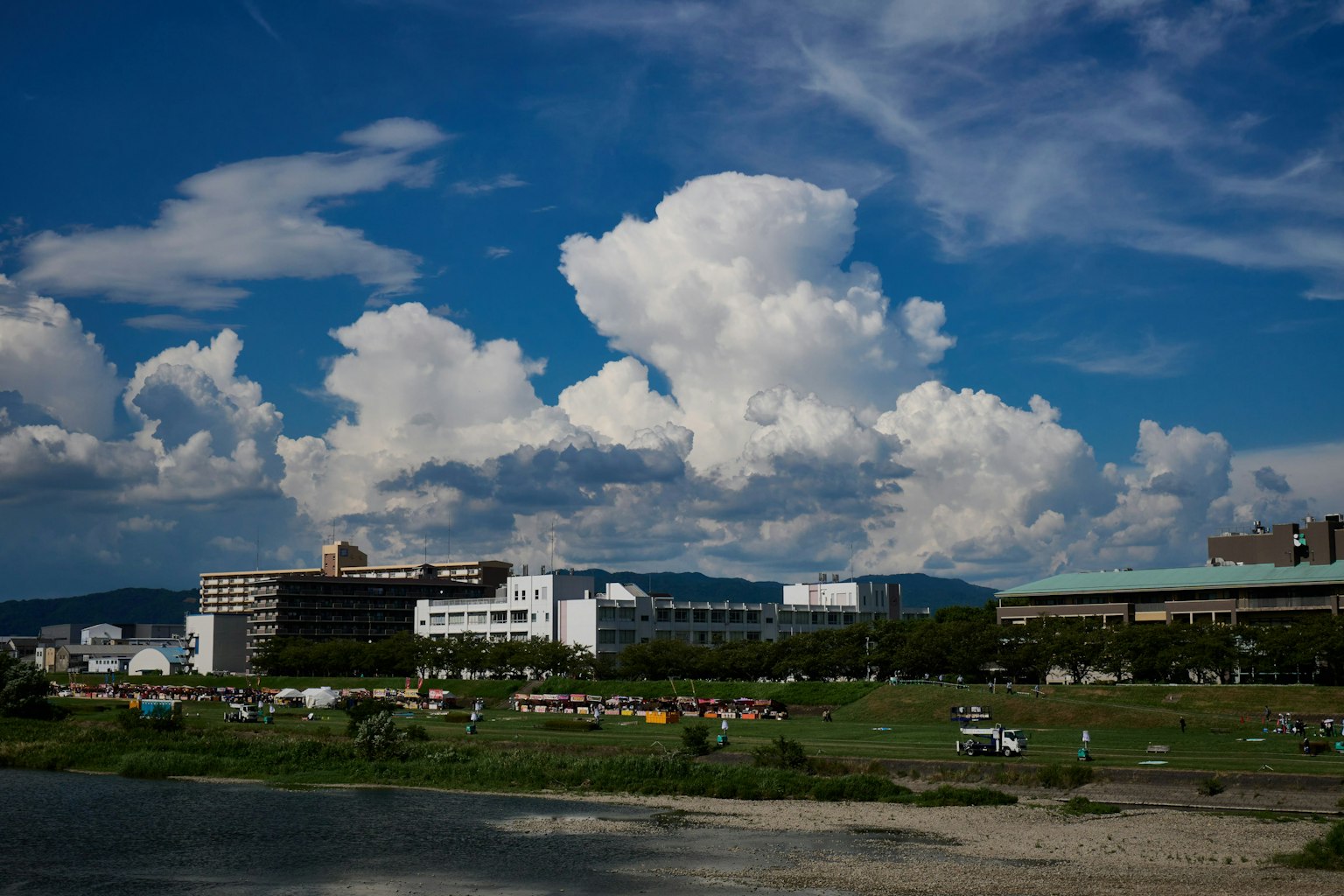 Paesaggio fluviale con cielo blu e nuvole che mostrano edifici