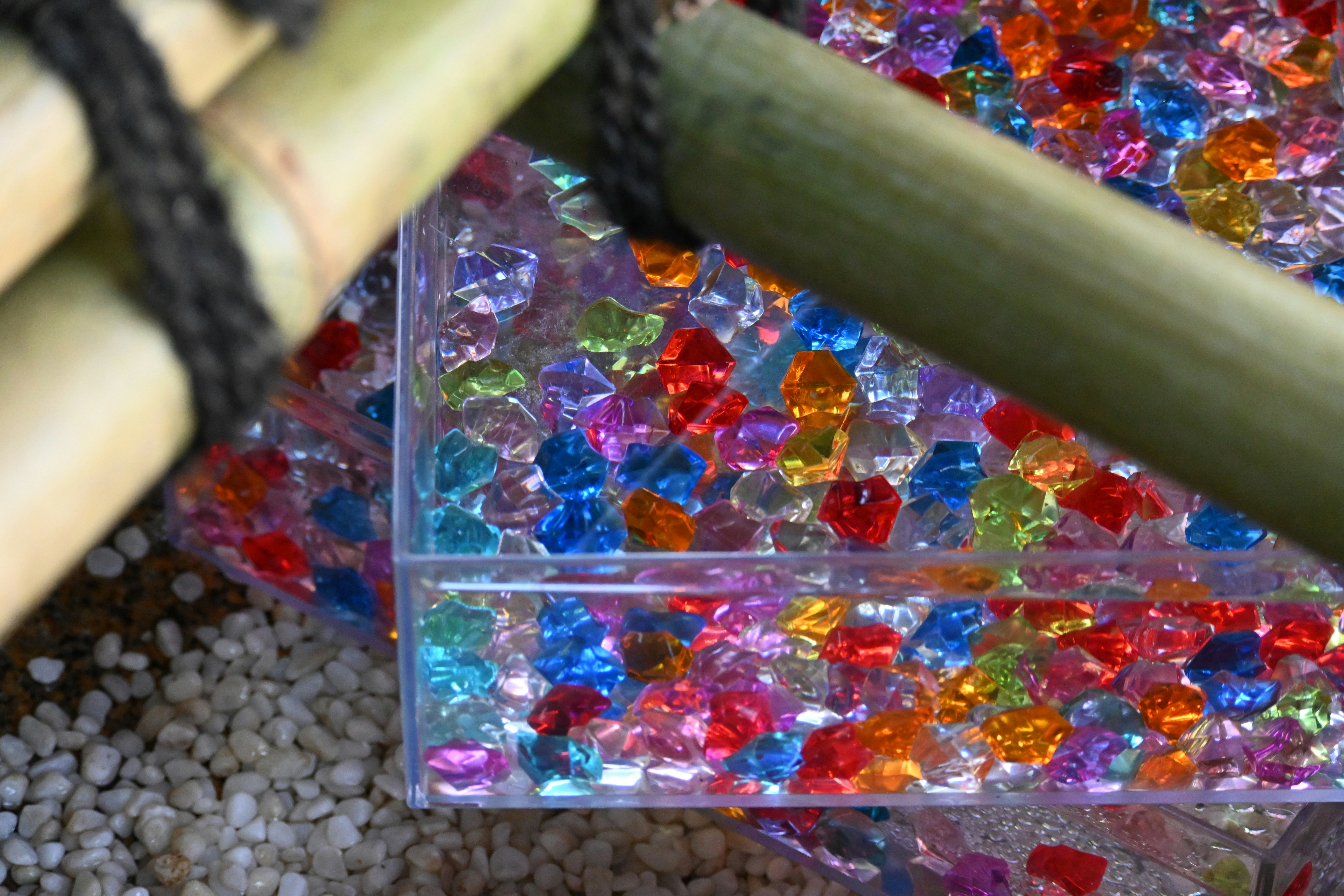 カラフルな手水舎の水鉢に並ぶ色付きガラス玉の涼感