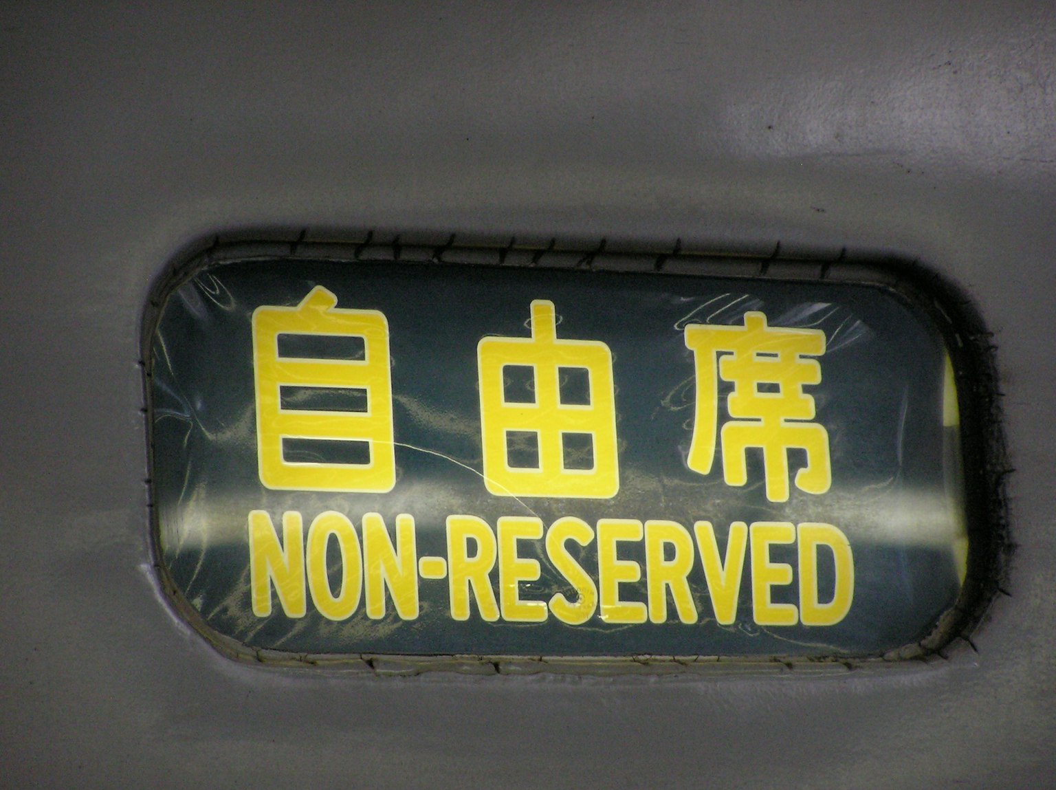 Sign indicating non-reserved seating with Chinese characters and English text
