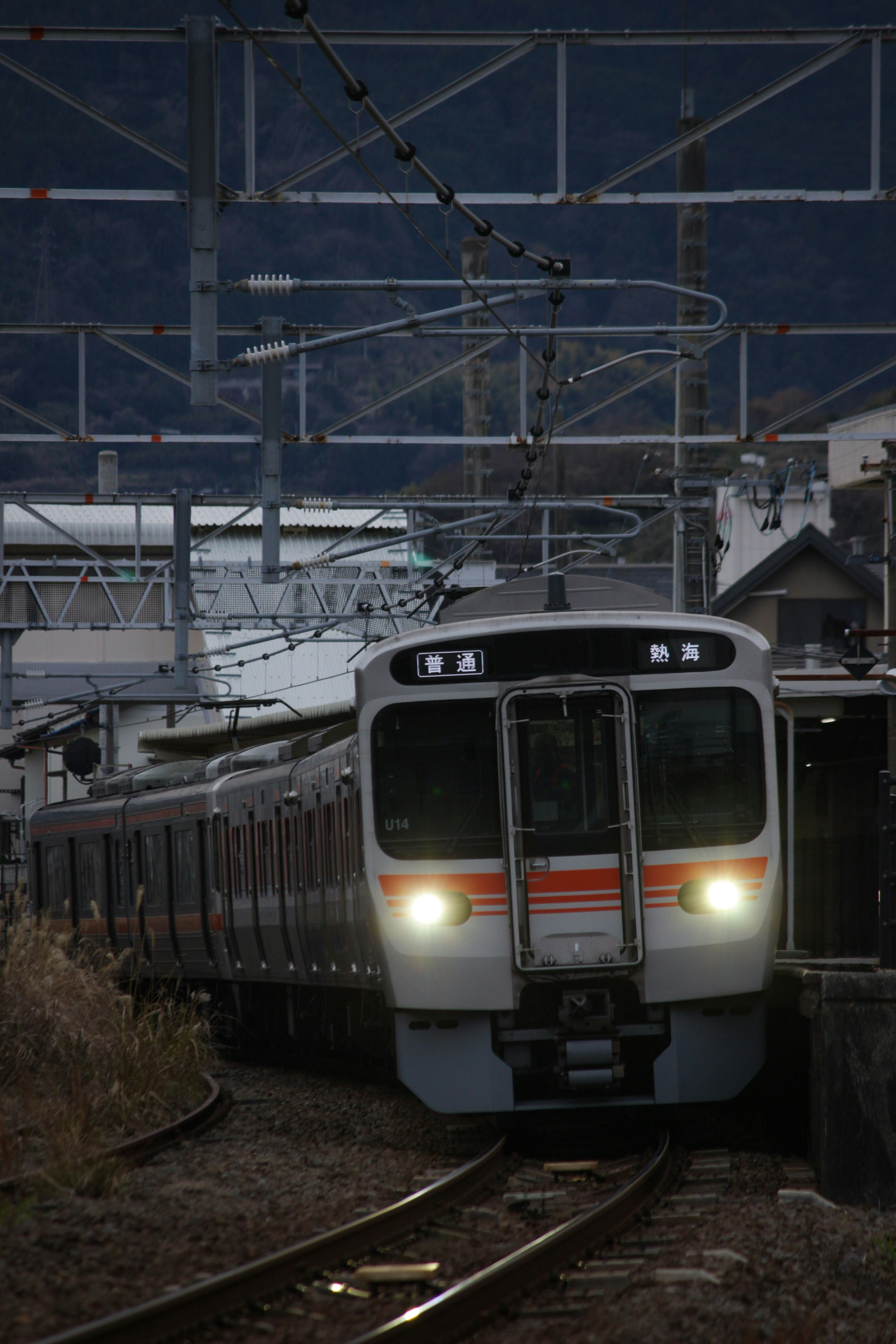 東海道本線の駅で発車する電車の前景