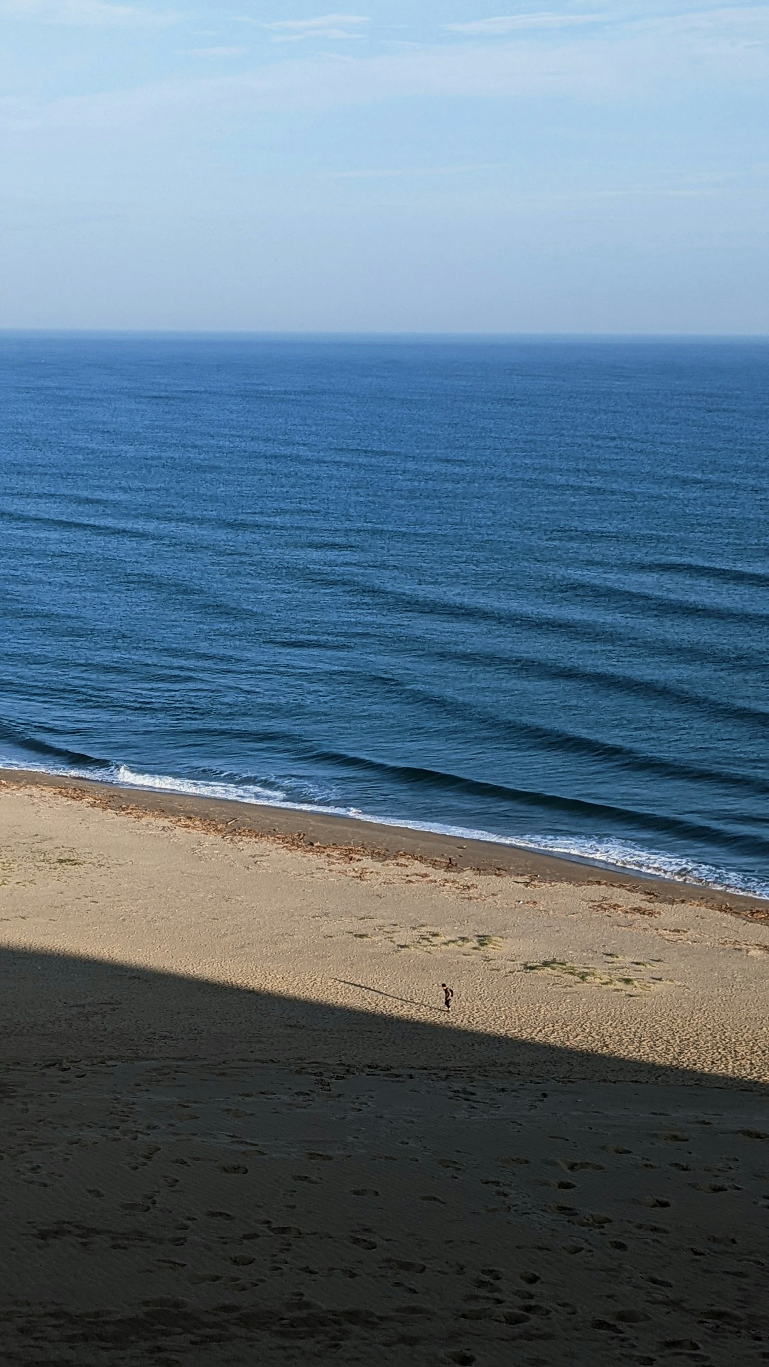 Vista di un mare blu calmo e di una spiaggia sabbiosa onde gentili