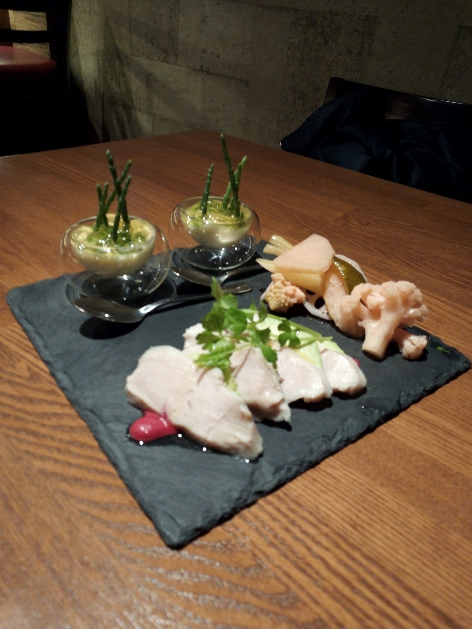 Frischer Sashimi auf einem Schieferplatte mit kleinen Glasbehältern für Vorspeisen