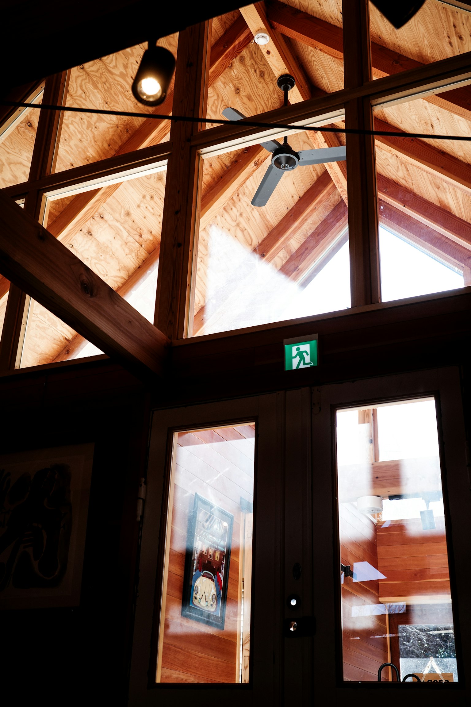 Entrada interior con vigas de madera y grandes ventanas