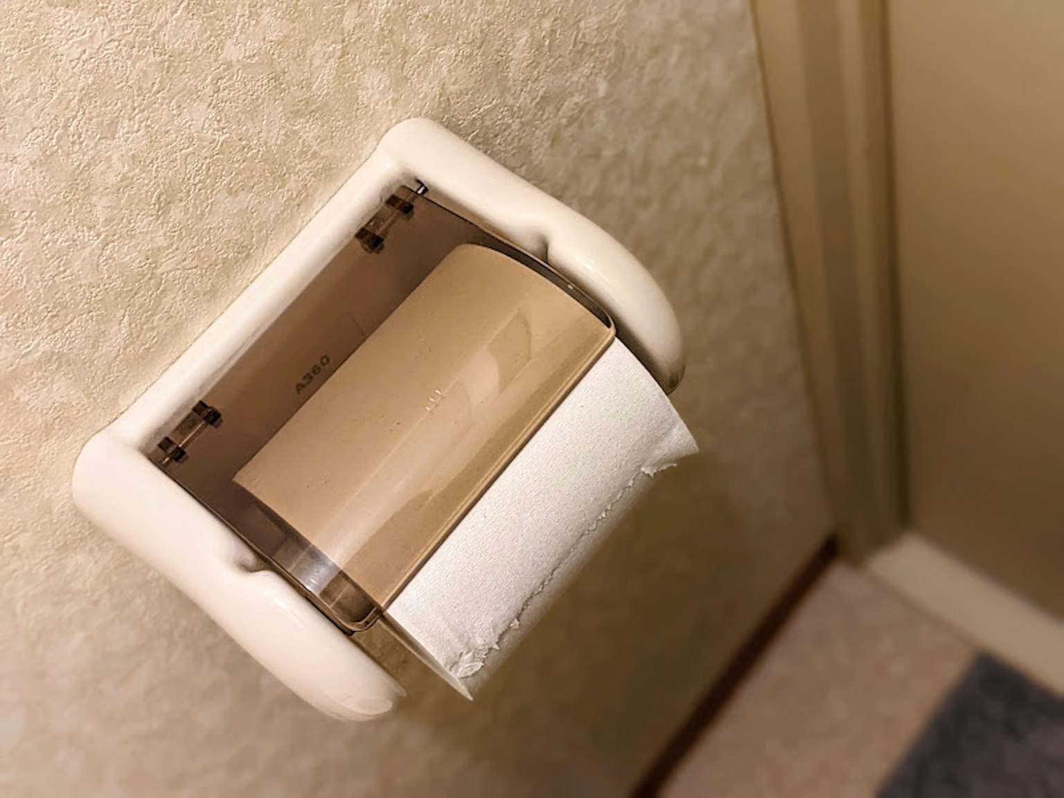 Tempat kertas toilet dengan gulungan kertas toilet