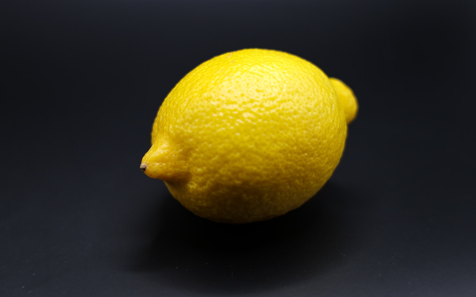 Limone giallo brillante posato su uno sfondo nero