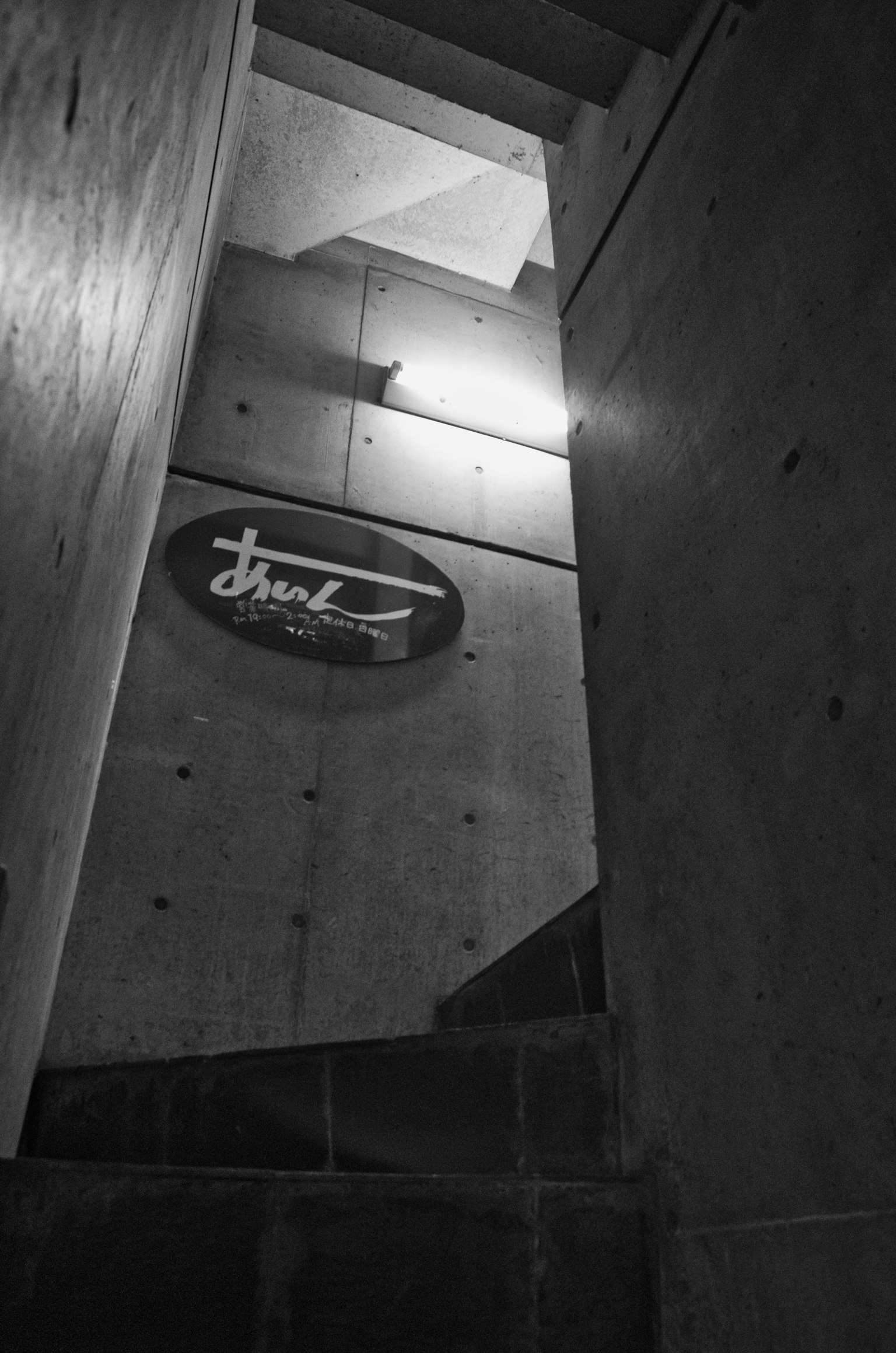Image of concrete walls and lighting from a viewpoint looking up the stairs