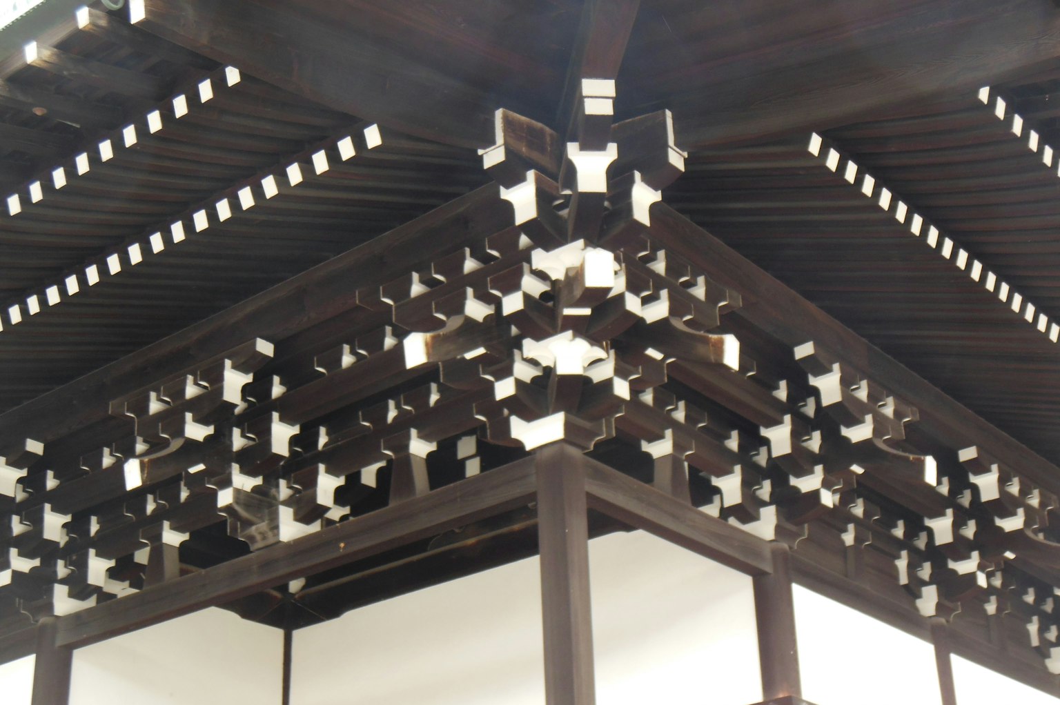 Detaillierte Ansicht einer traditionellen japanischen Dachstruktur mit Holzbalken und sich kreuzenden Designs