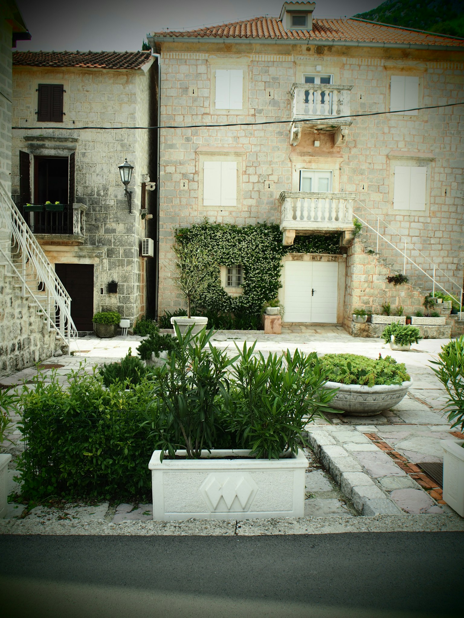 Plaza tranquila con casas de piedra y vegetación exuberante
