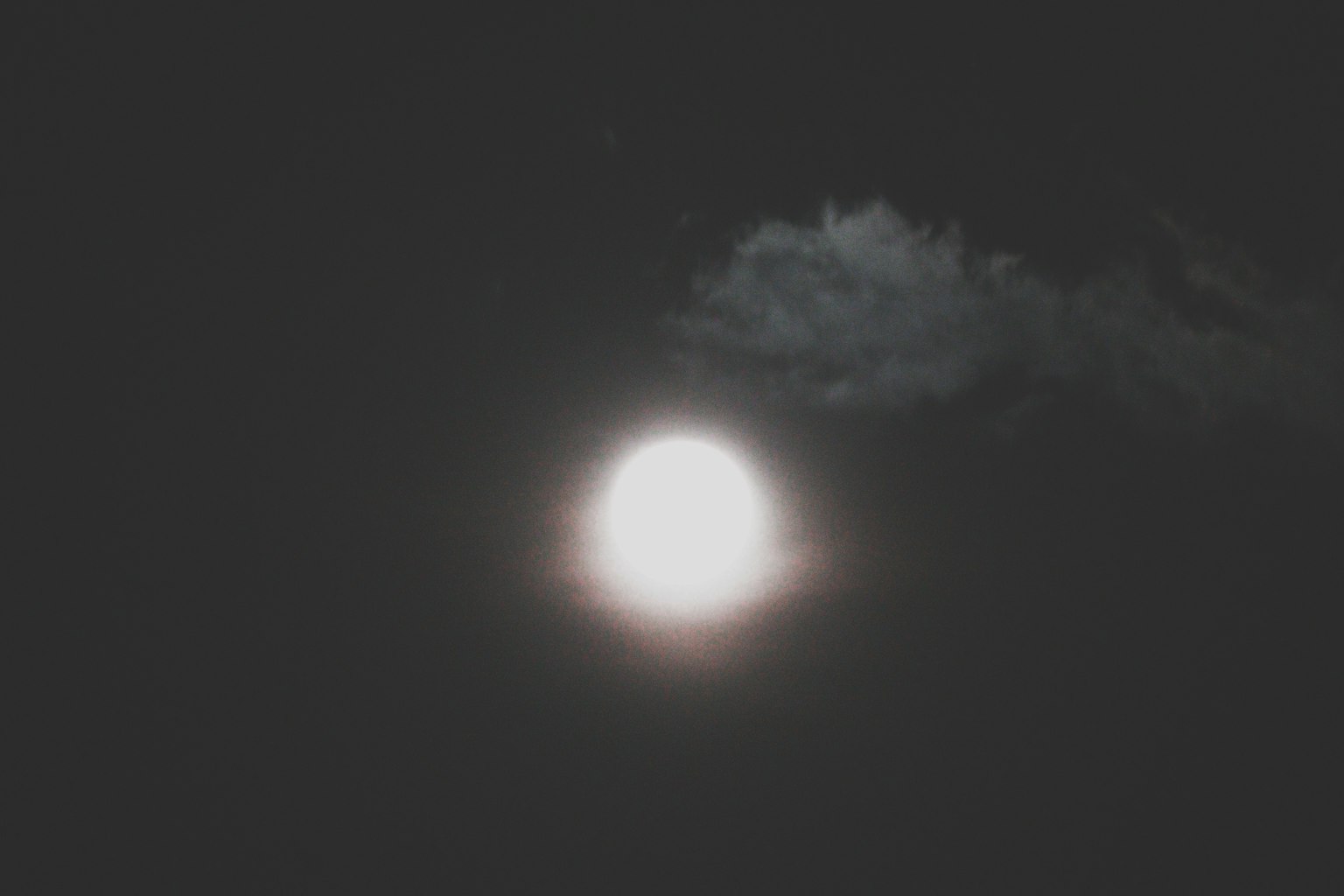 Lune brillante dans un ciel nocturne sombre avec des nuages légers