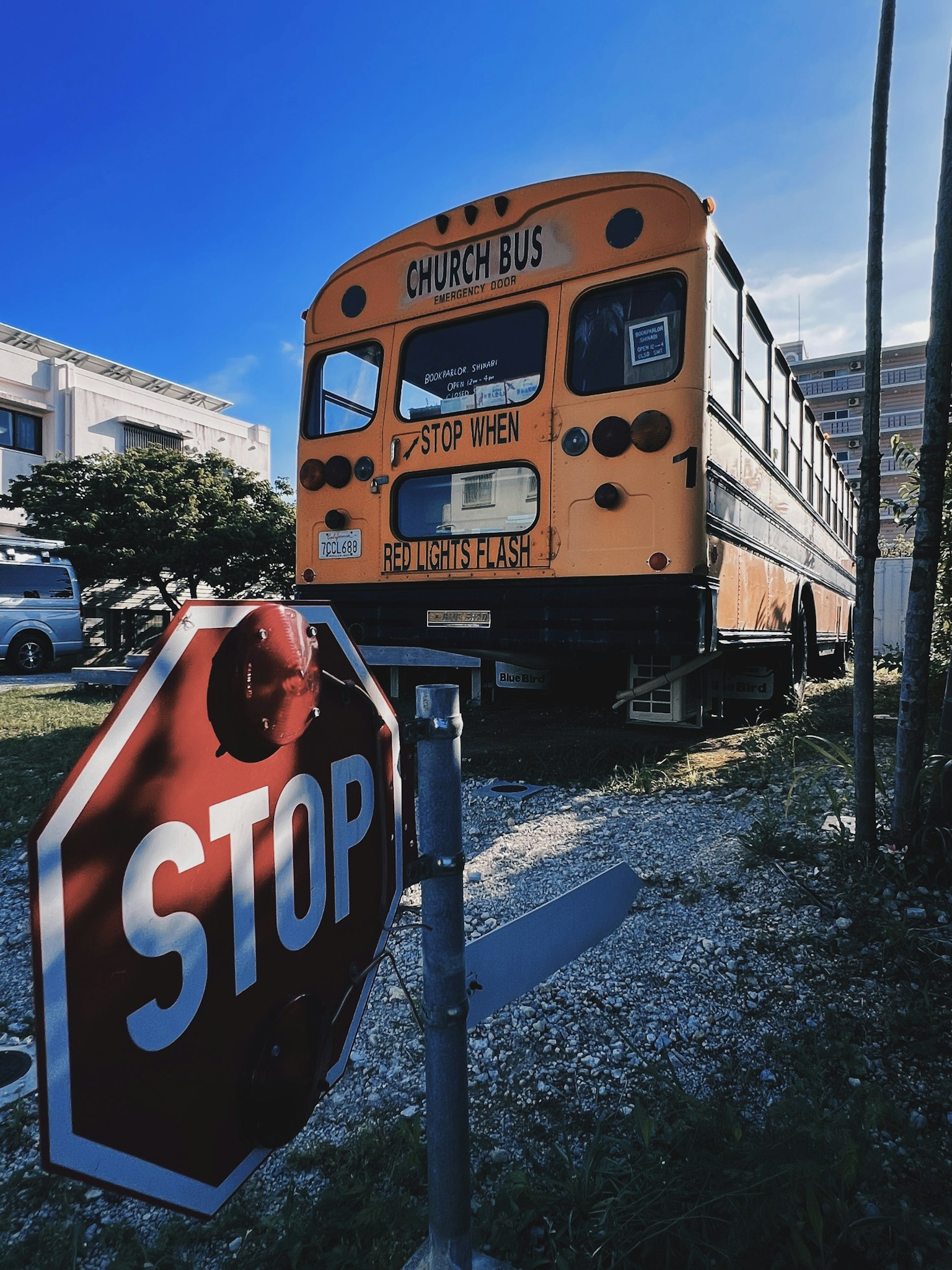 Un autobus scolastico arancione accanto a un segnale di stop rosso in un'area erbosa