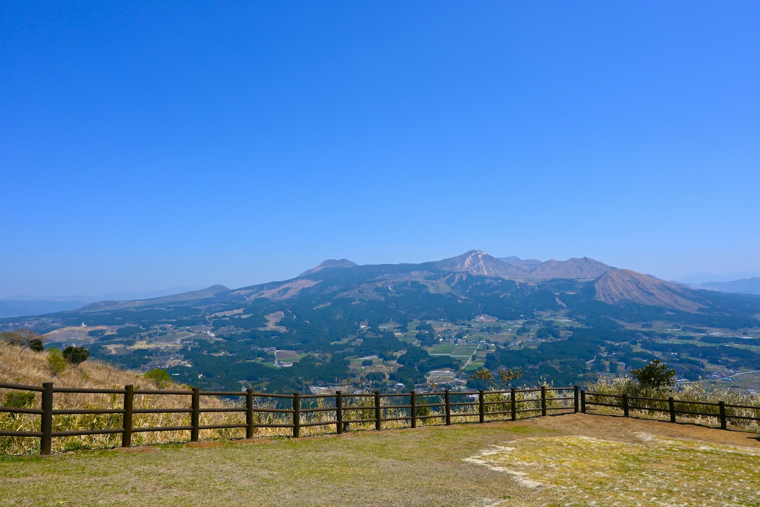 Hermoso paisaje montañoso bajo un cielo azul claro con pastizales