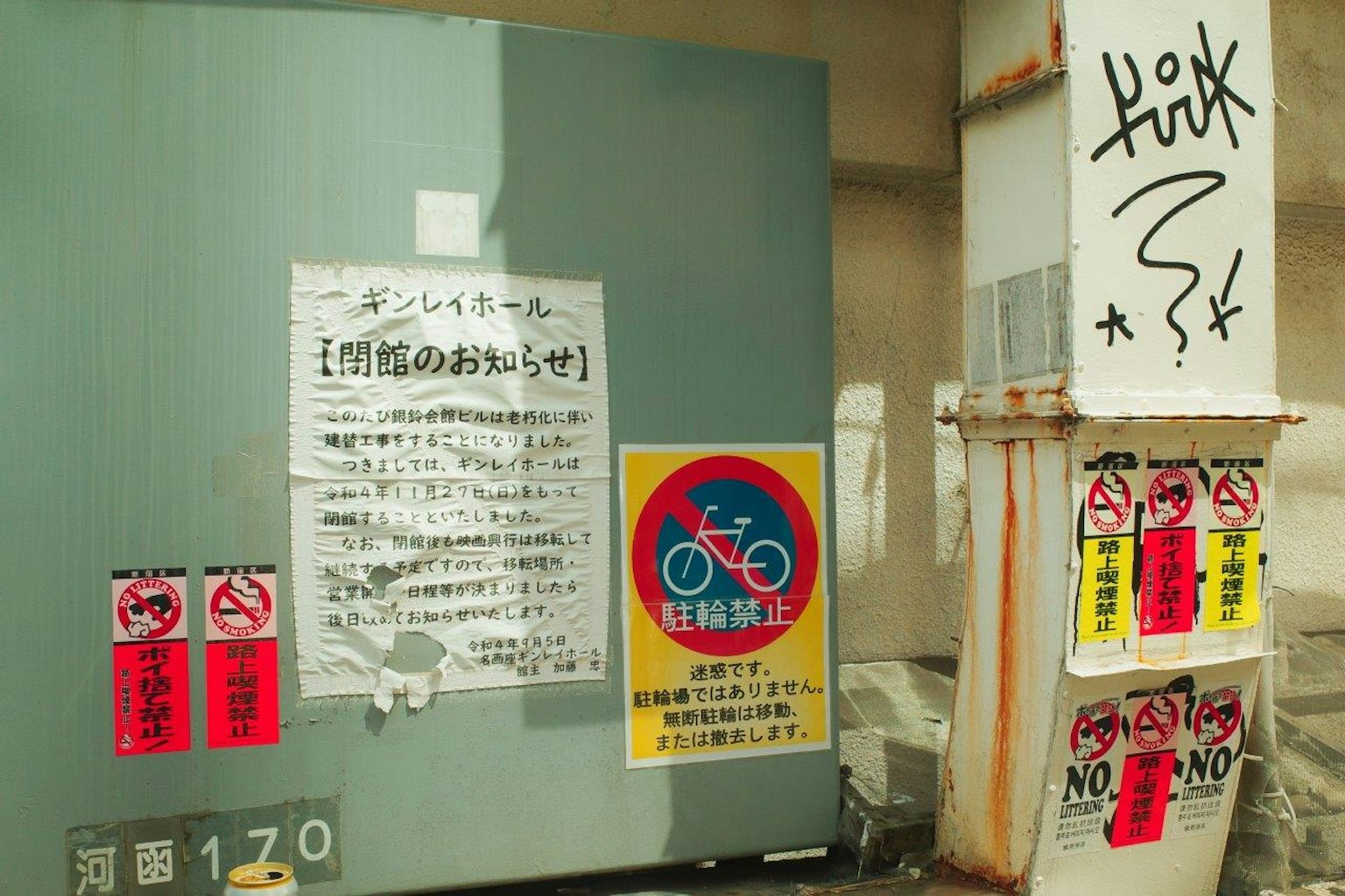 Posters of prohibitions and graffiti on a wall