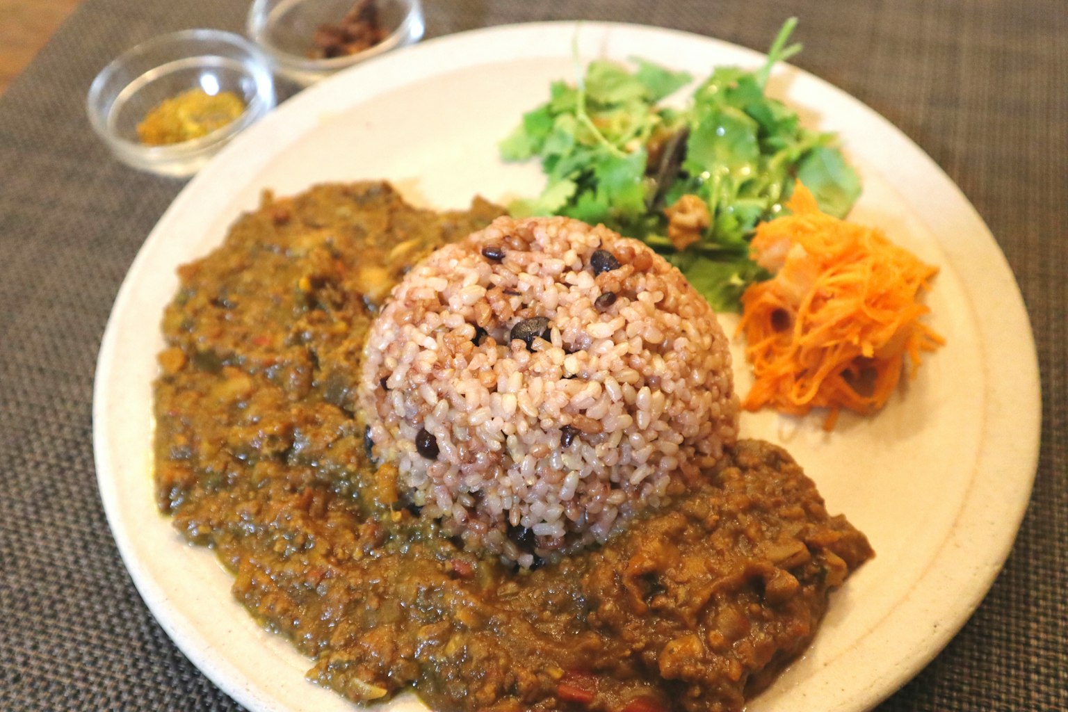 Un plato con arroz integral, salsa de curry y verduras variadas