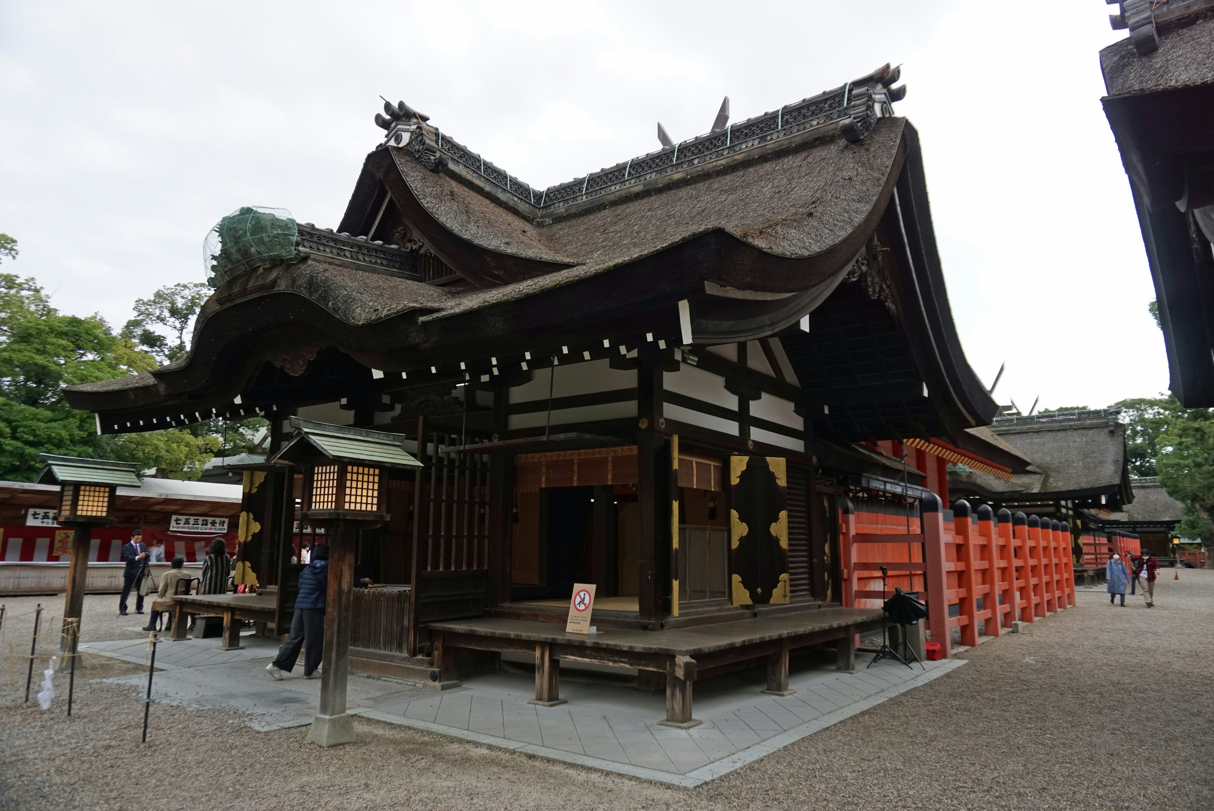 Shinto-Schrein mit Gebetshalle und roten Opferständern entlang des Zugangs