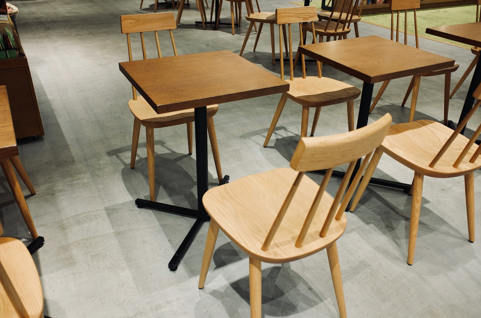 Interno di un caffè con tavoli e sedie in legno disposti