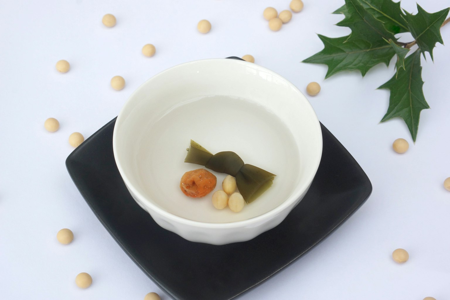 黑色盤子上的清湯和蔬菜豆的碗