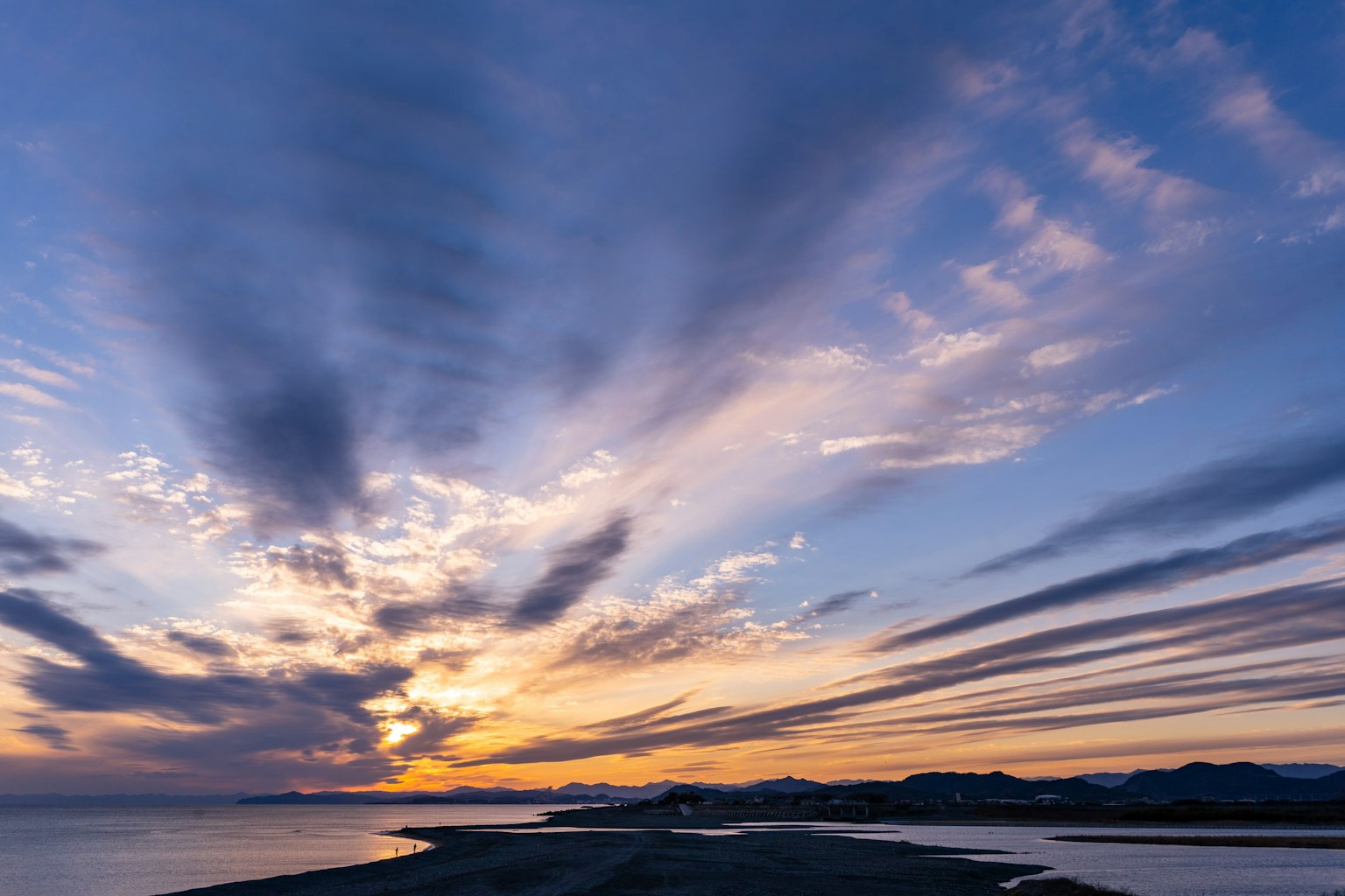 Stunning sunset with vibrant clouds and a tranquil shoreline