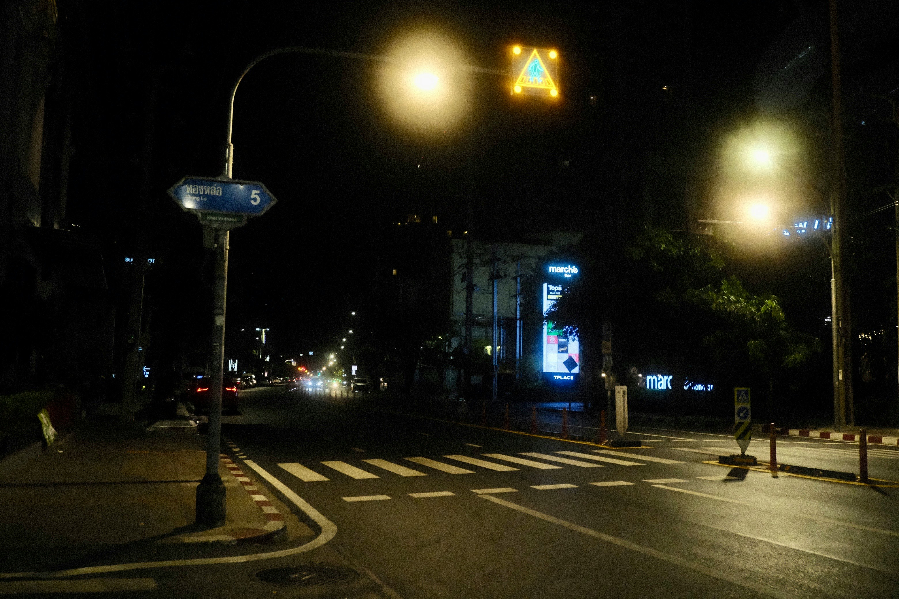 夜の交差点で信号と標識が光る街並み