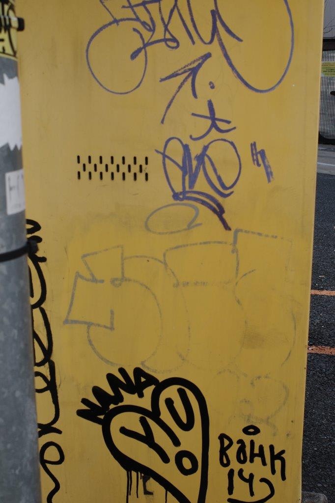 Graffiti an einer gelben Wand