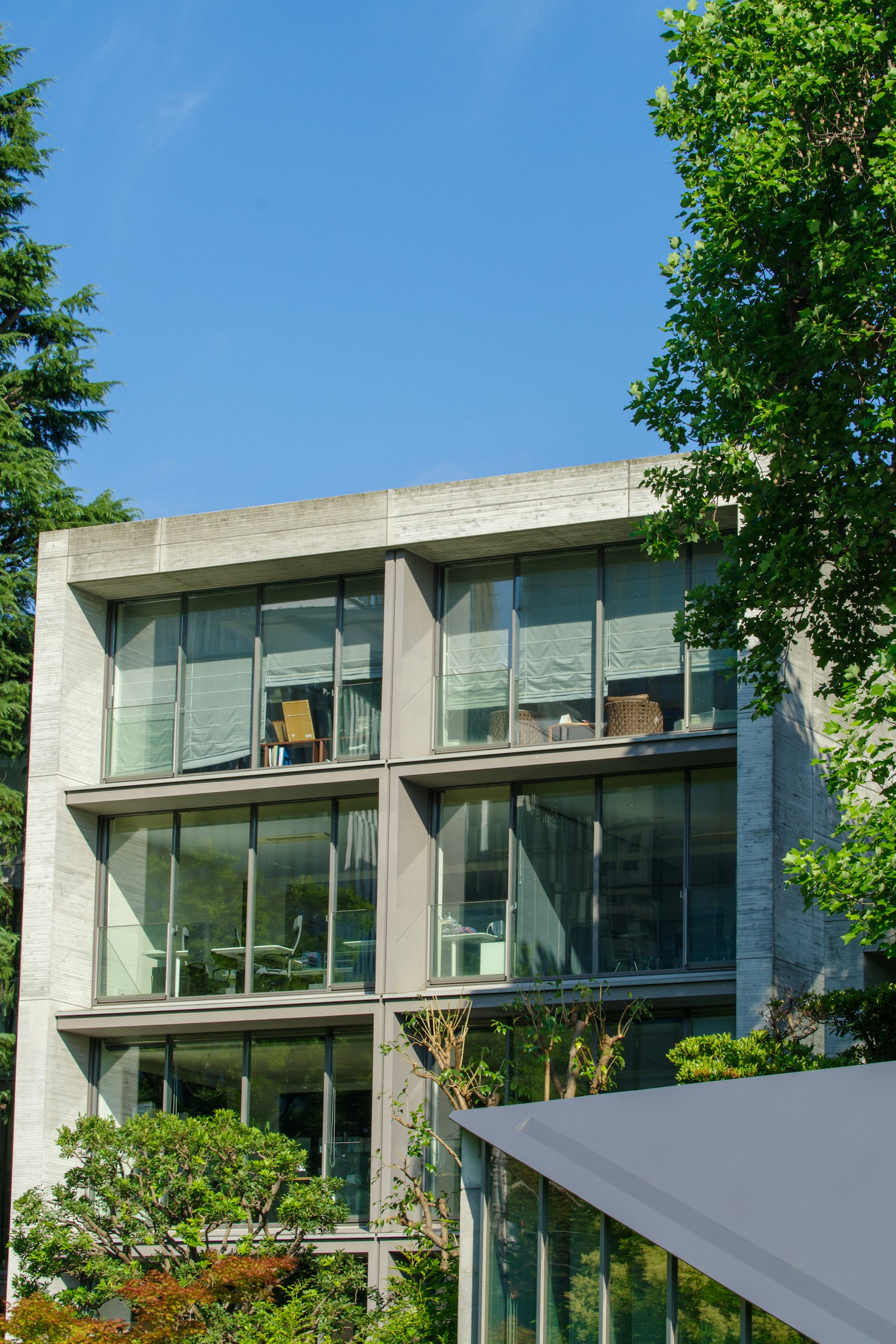 Bâtiment moderne en béton avec de grandes fenêtres et de la verdure