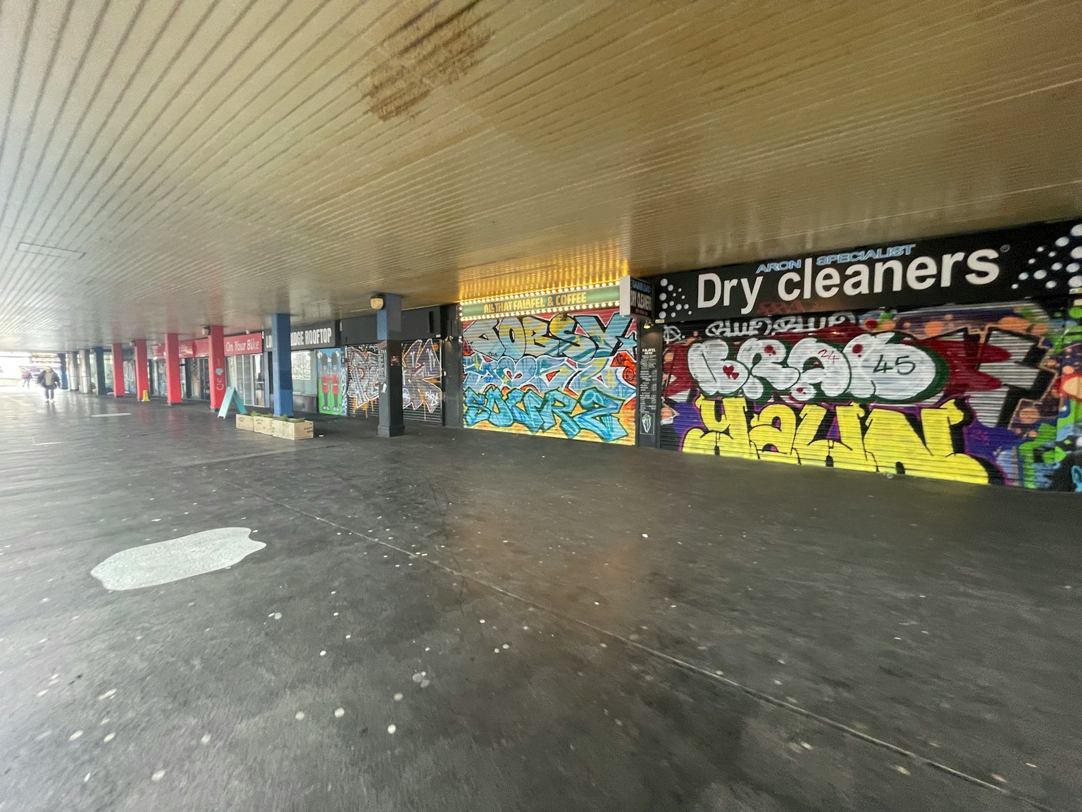 A corridor featuring various graffiti artworks on the walls
