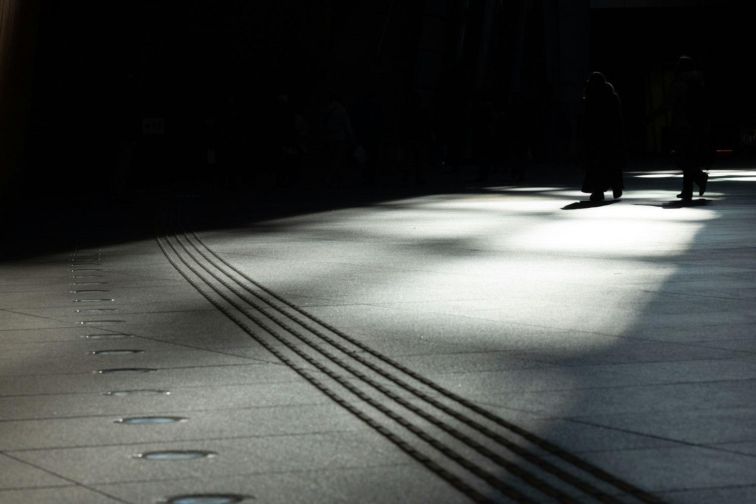 Ombres projetées sur un sol avec de la lumière filtrant d'un fond sombre