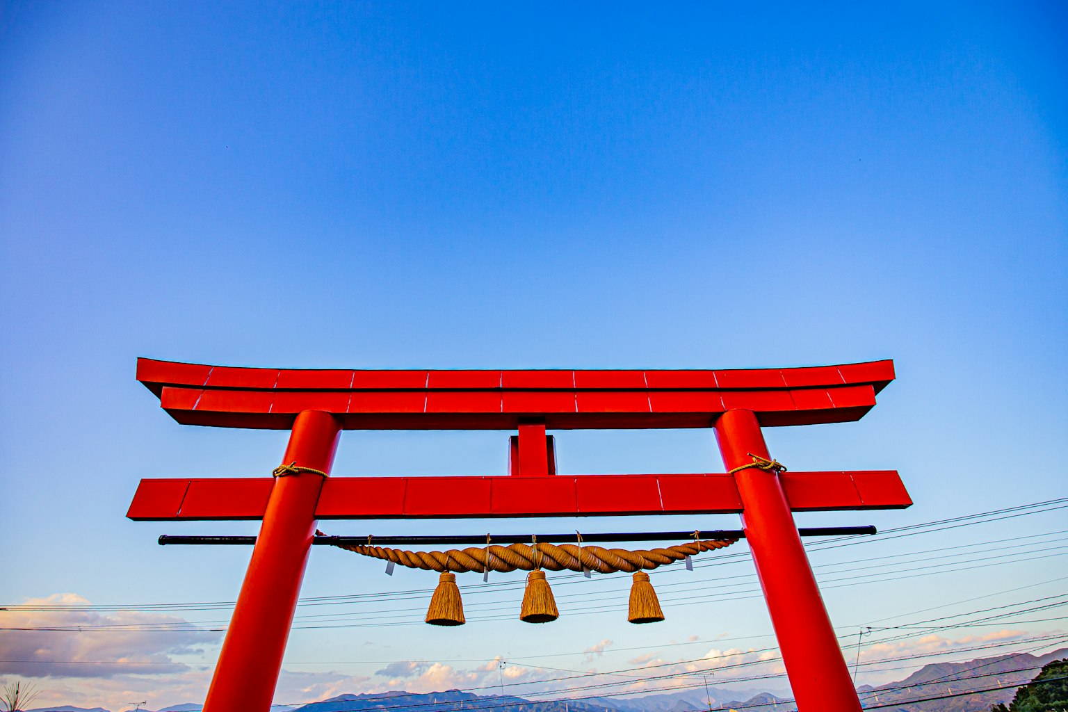 Cổng torii màu đỏ đứng dưới bầu trời xanh