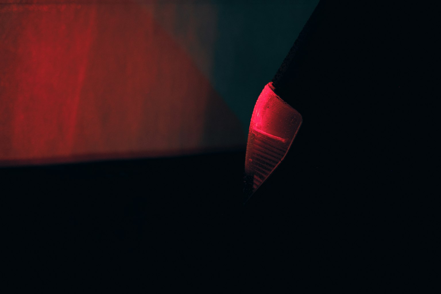 Partie d'un objet éclairée par une lumière rouge sur fond sombre