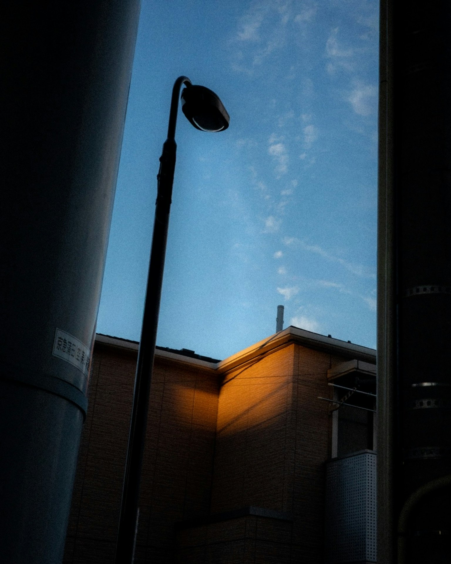 青空と建物の一部が見える街の風景街灯が立っている