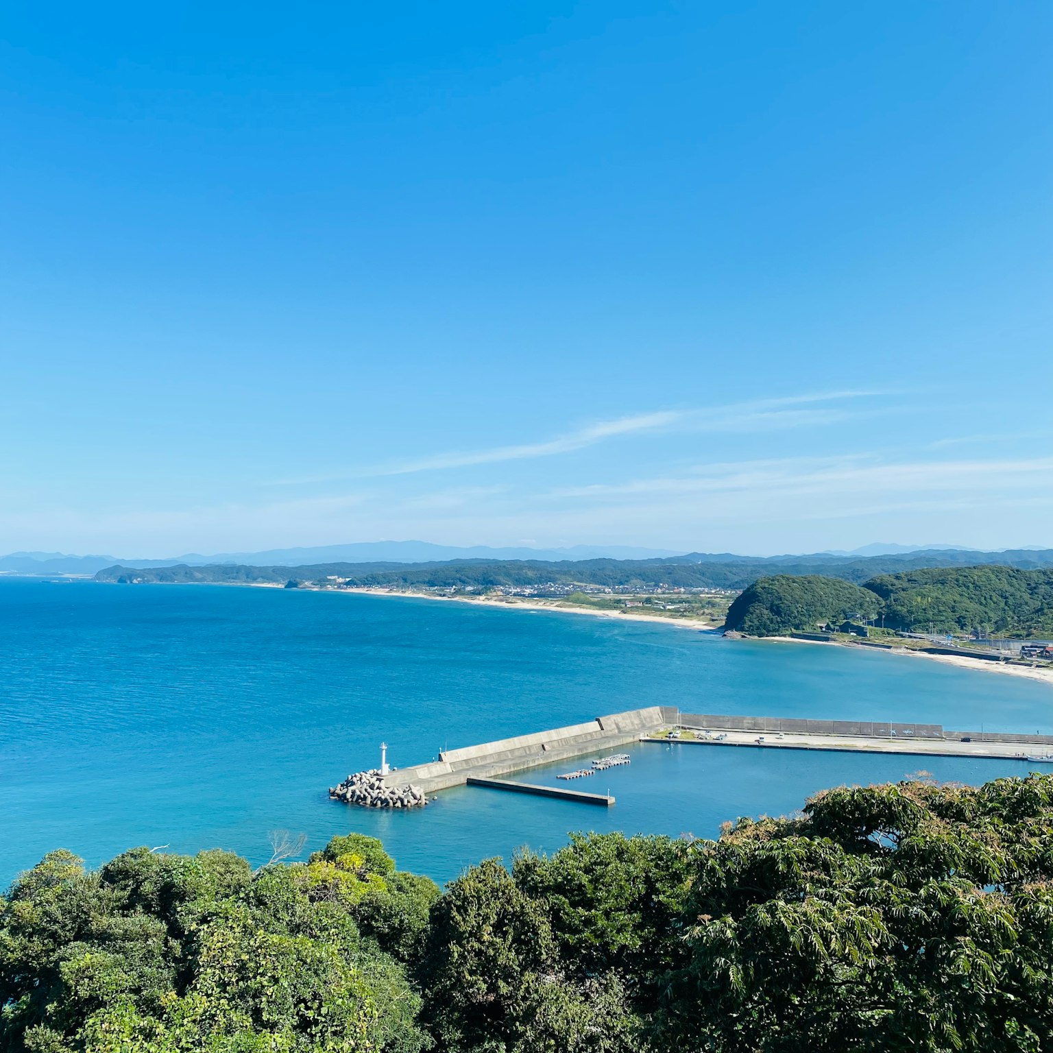 Vue panoramique de la mer bleue et du ciel avec un port et un brise-lames