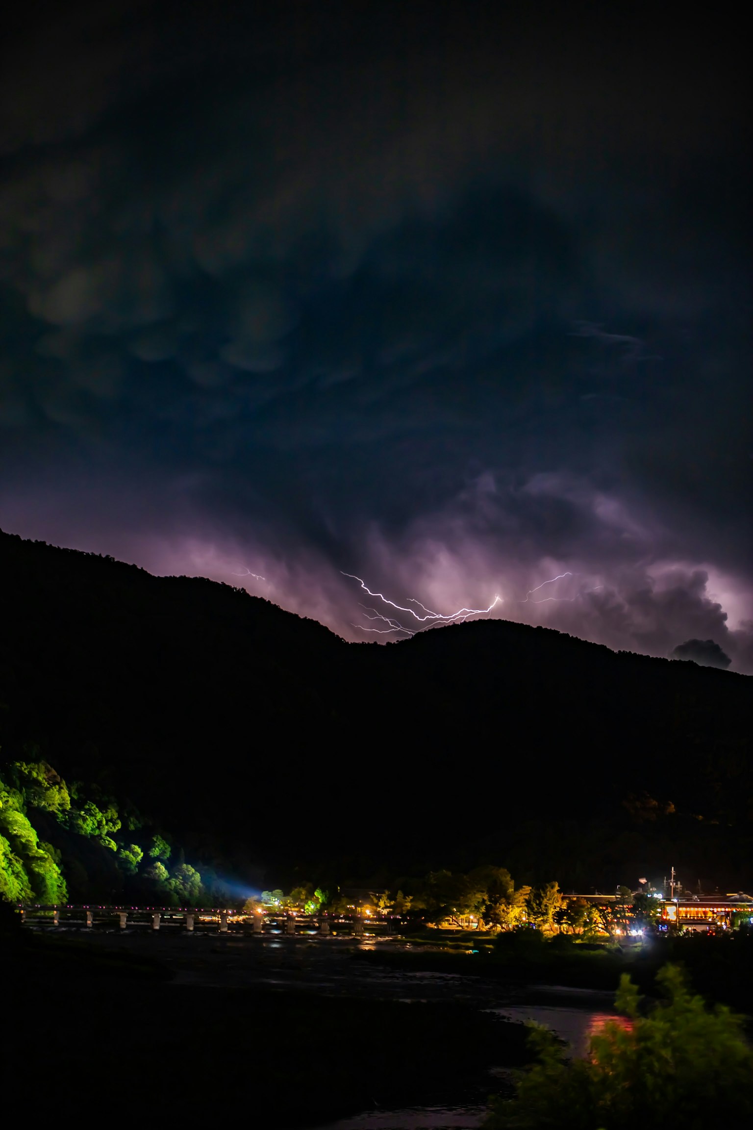 Mountain landscape with stormy clouds and lightning at night