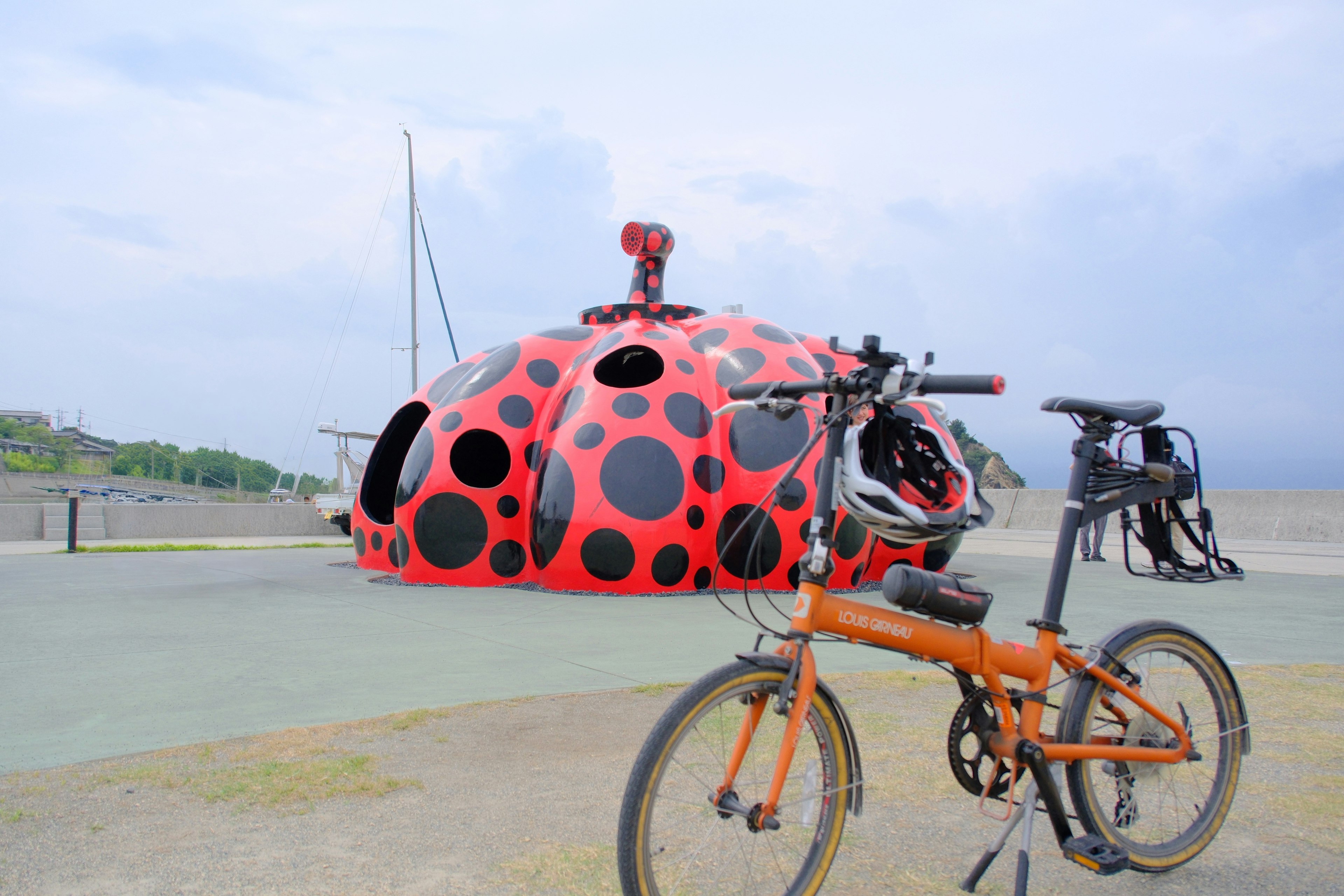 赤い水玉のアートバスと自転車のある屋外の広場