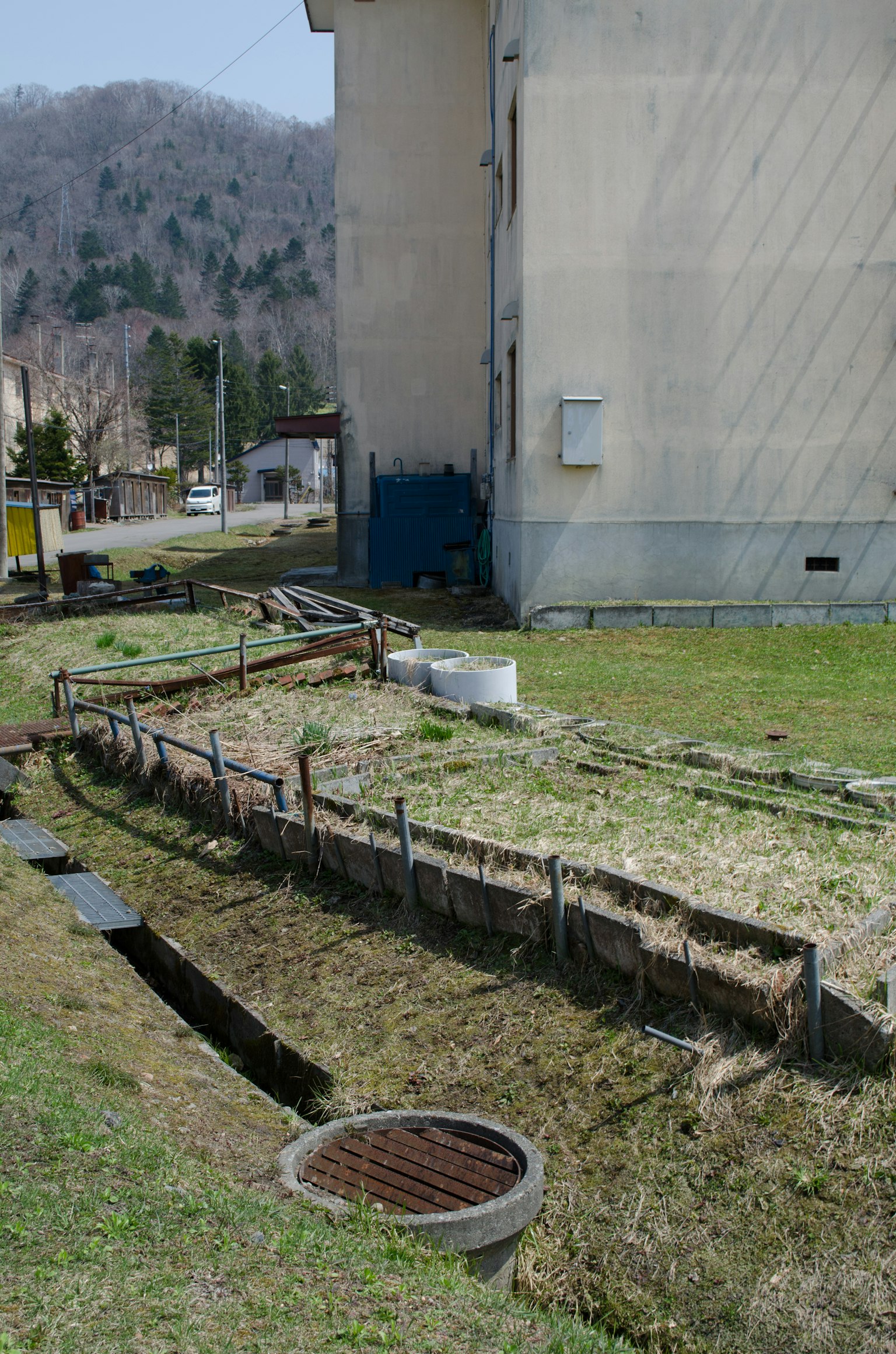 Paesaggio con una lunga trincea e un coperchio di drenaggio accanto a un edificio
