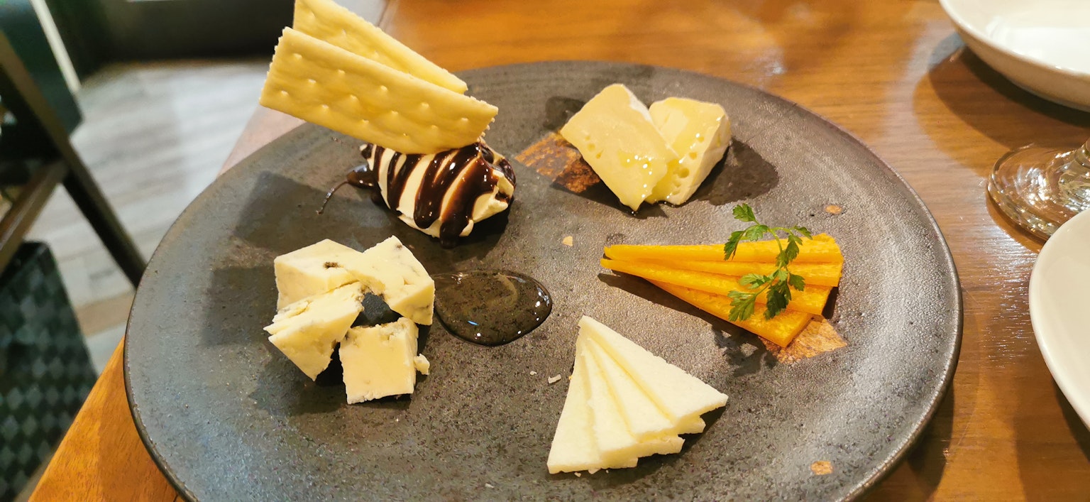 Un assortimento di dessert su un piatto nero con salsa al cioccolato e cialde