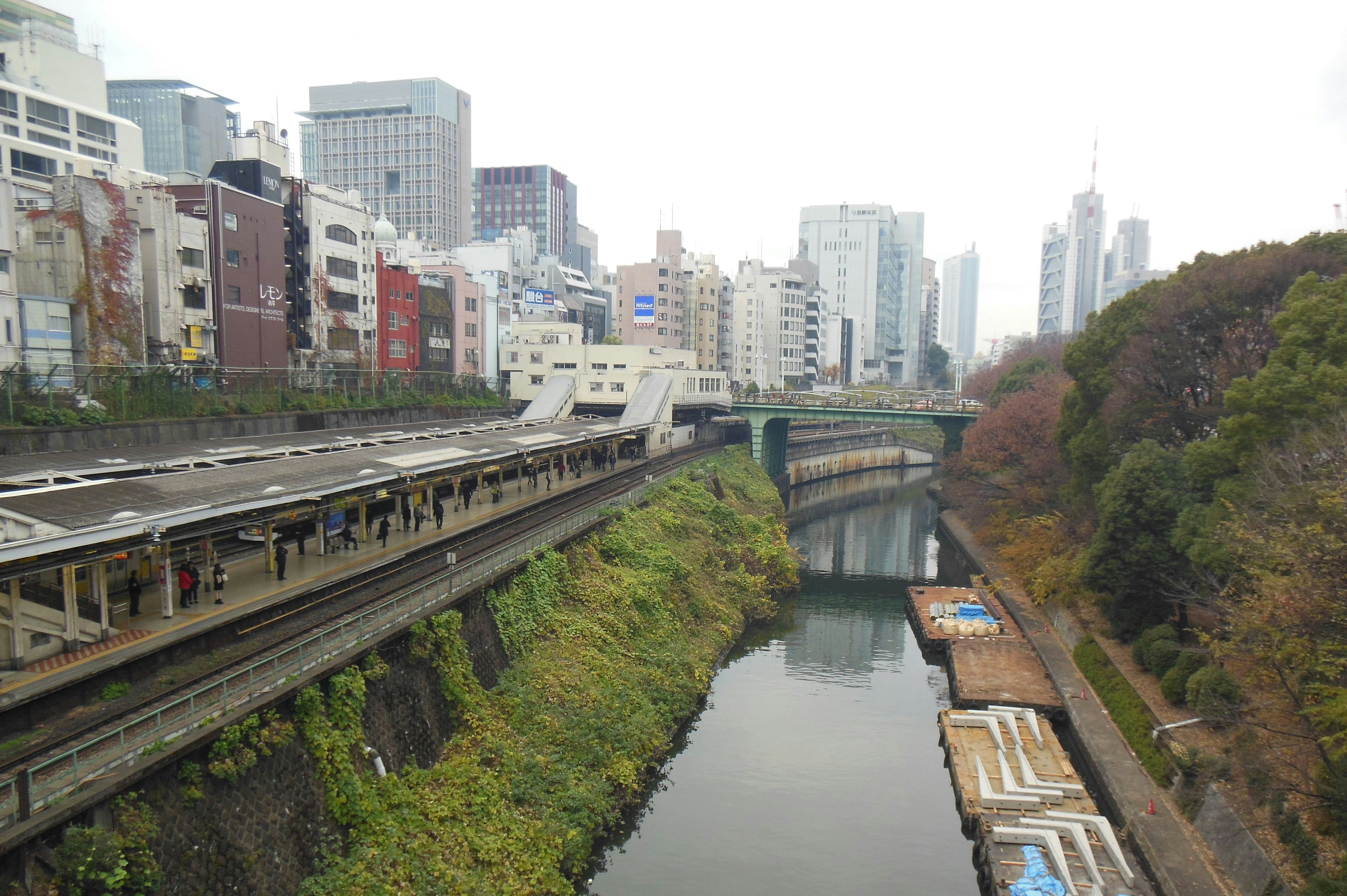 川沿いを走る高架線路と都市のビル群