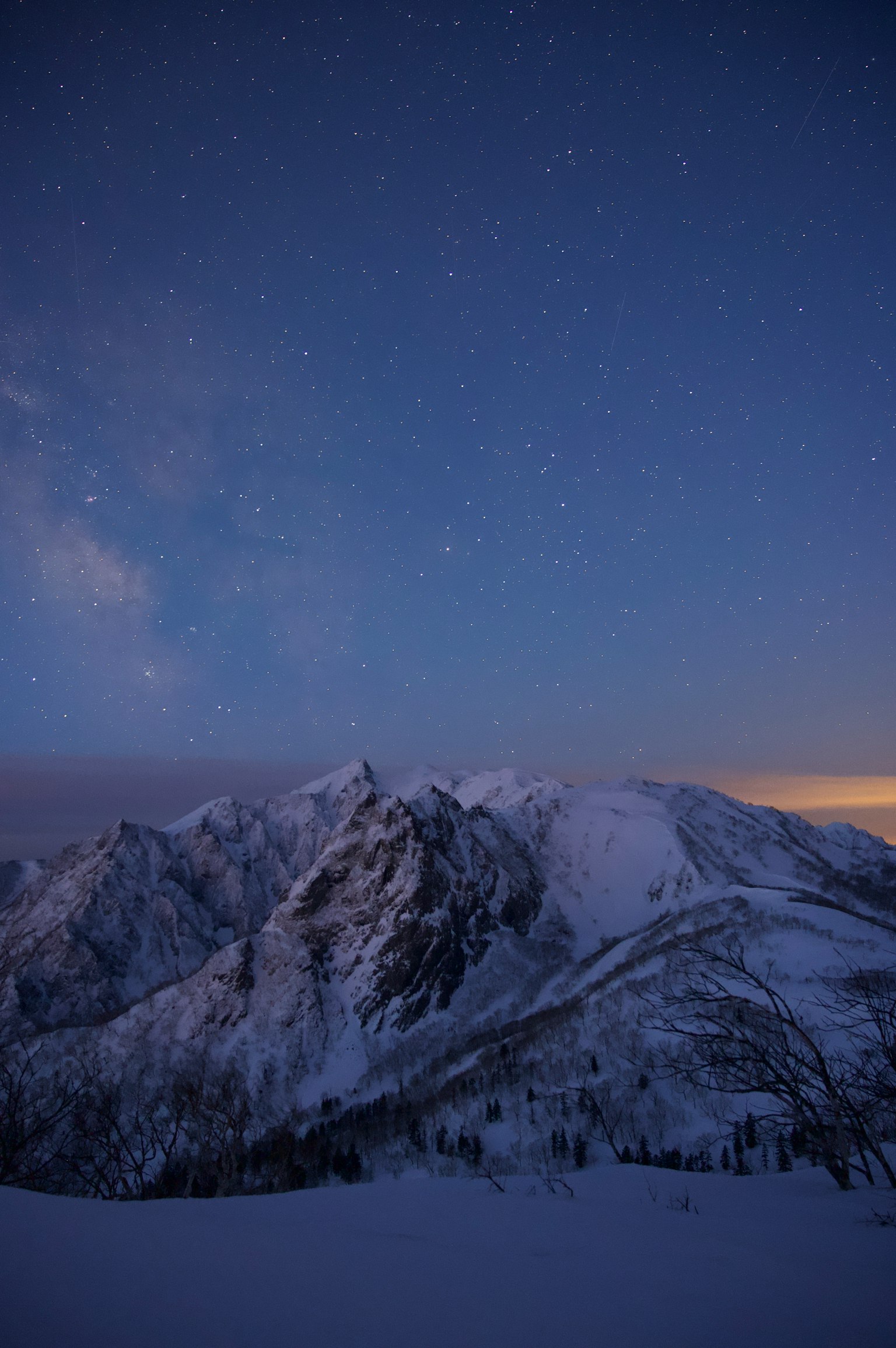 Montagnes enneigées sous un ciel étoilé