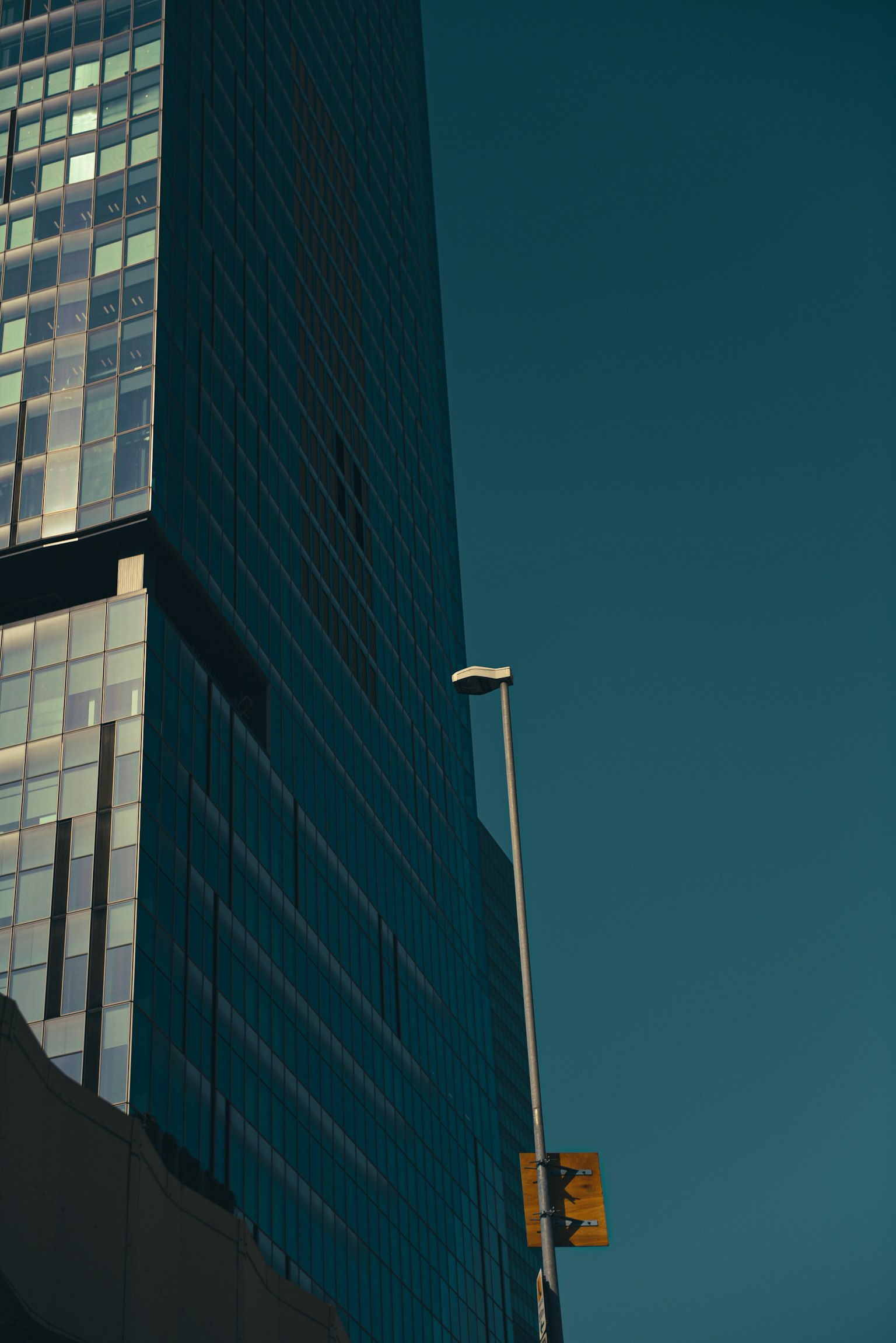 Urban scene featuring a tall glass building and a streetlight