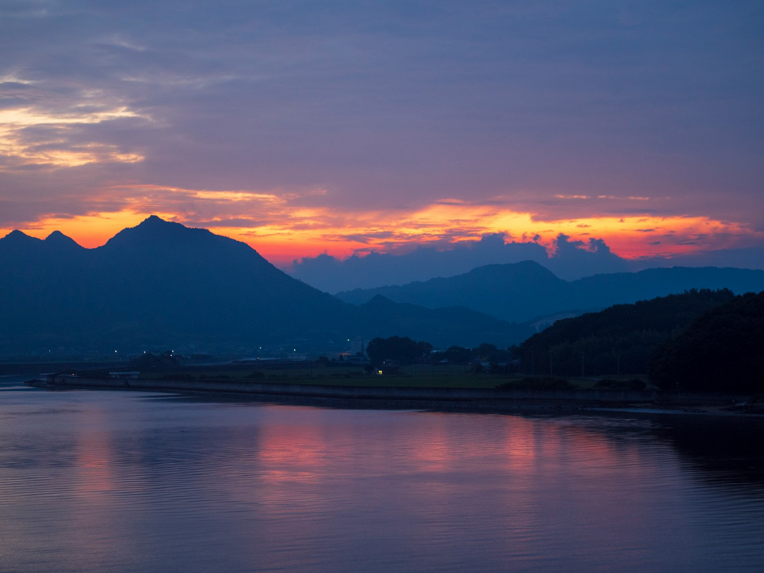 Coucher de soleil sur les montagnes et la rivière calme
