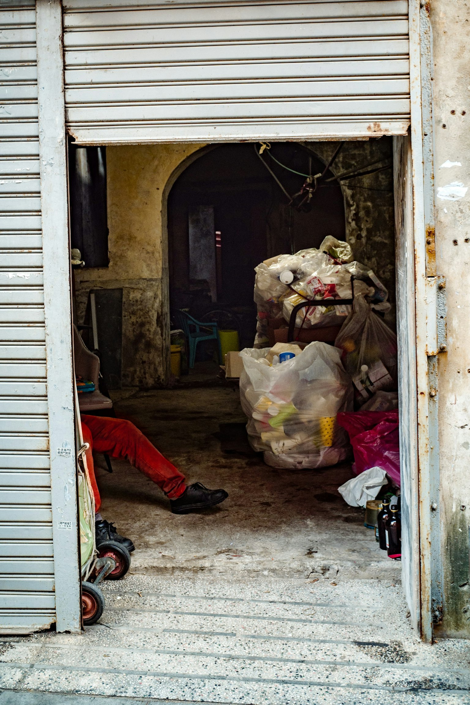 廃棄物が積まれた狭い通路の入り口の写真