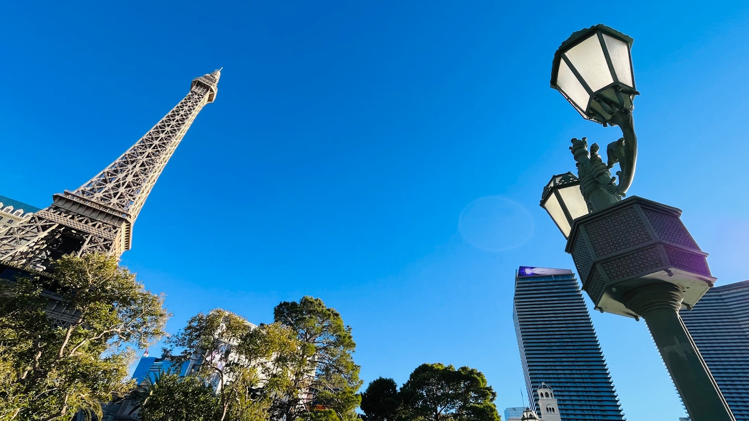 Blick auf den Eiffelturm und eine Straßenlaterne unter einem klaren blauen Himmel