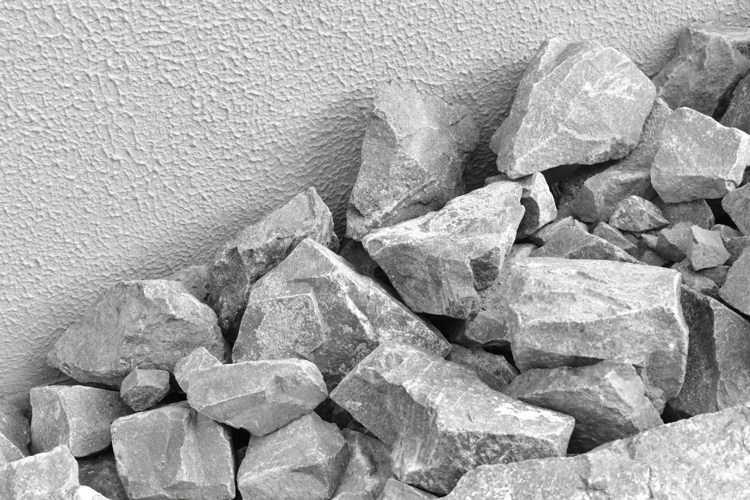 Imagen de rocas grises apiladas cerca de una pared texturizada