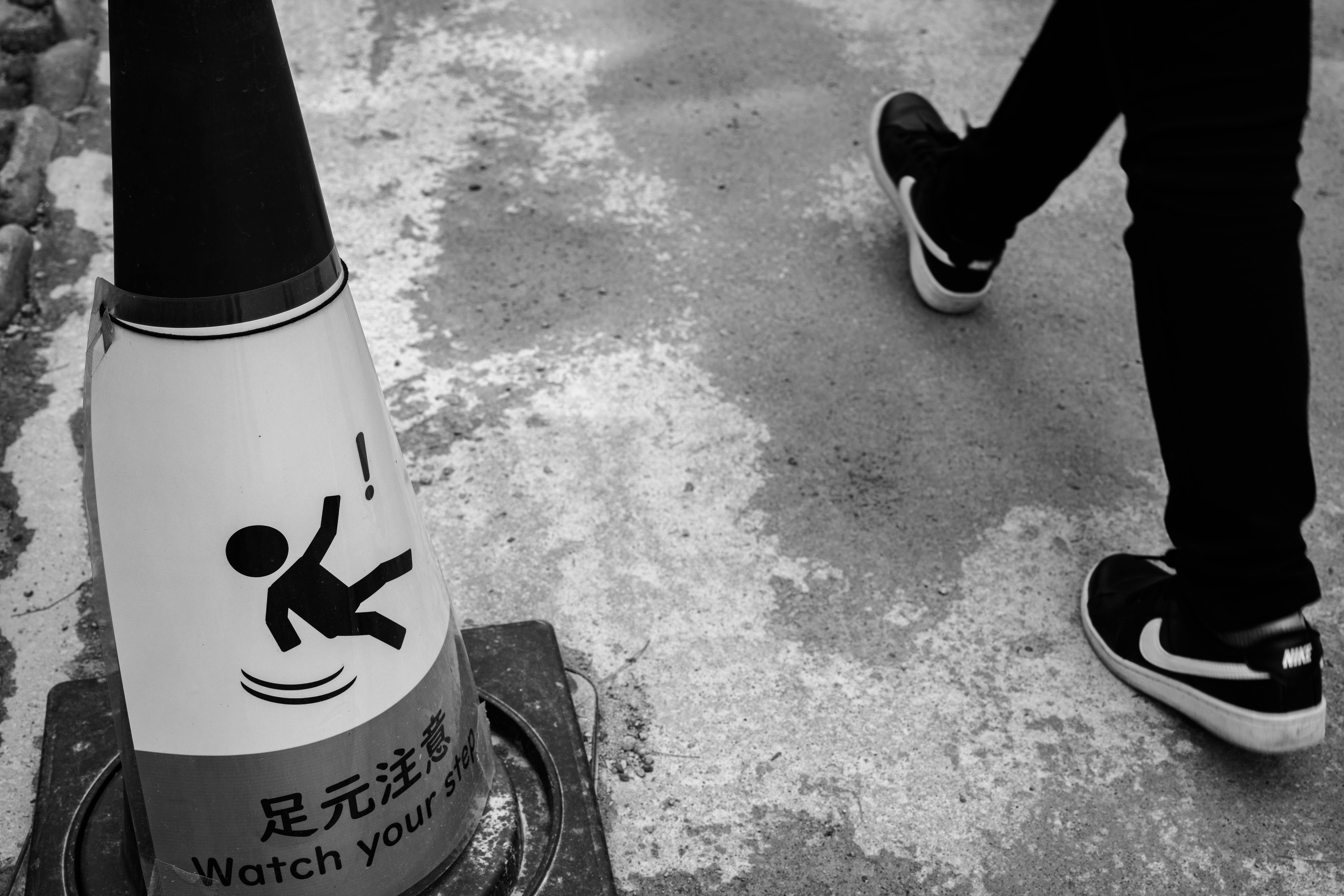 eine Getränkeflasche auf der Straße mit Sneakers daneben